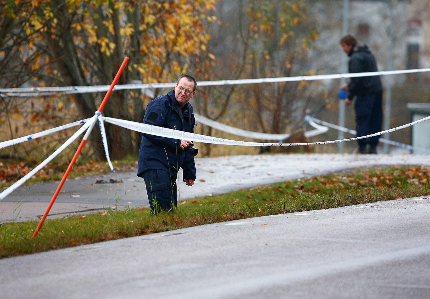 Polisens tekniker på plats i Ljungsbro där kvinnan och pojken dödades.