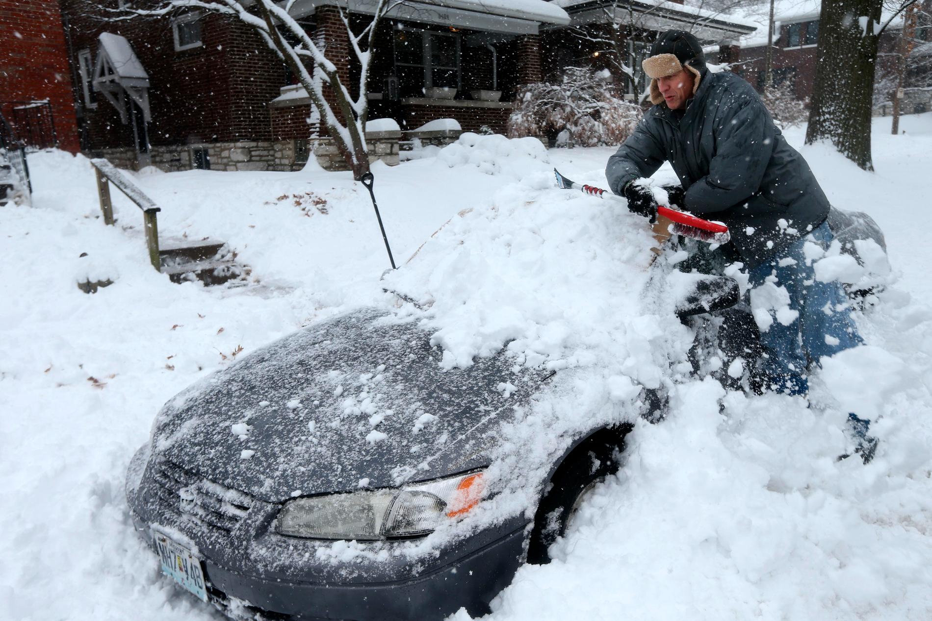 En man i Kansas skottar fram sin bil efter snöovädret som härjat i den amerikanska delstaten.