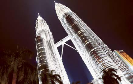Tvillingtornen Petronas towers reser sig mäktigt i kvällsbelysningen. Tornen var en gång världens högsta byggnad och de är fortfarande ett landmärke i Kuala Lumpur.