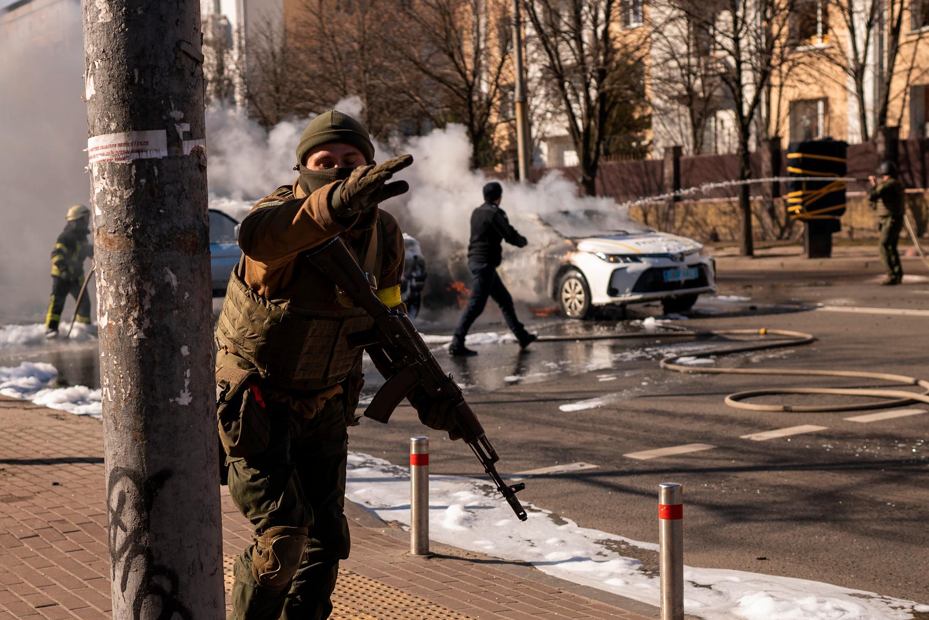 Brinnande bilar släcks på en gata i Kiev. 