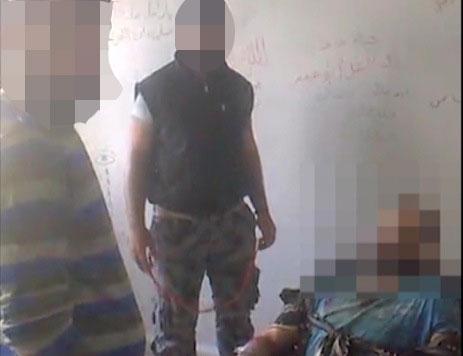 Bild ur videofilmen som visar misshandeln av en fånge.