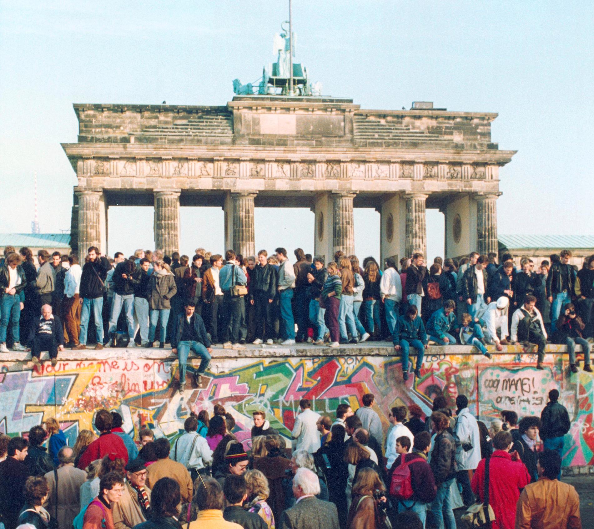 Människor från Öst- och Västberlin på muren vid Brandenburger Tor den 10 november 1989.