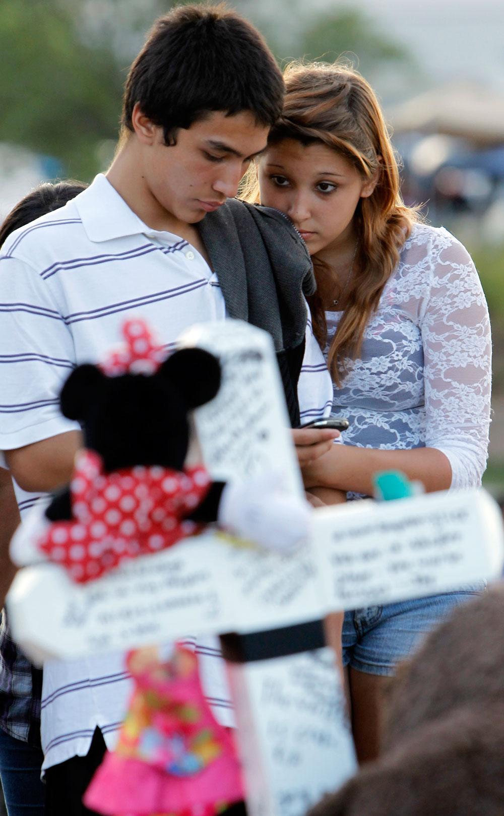 Jovandy Juarez och Angelica Chacon-Valdez tröstar varandra under en minnesceremoni för offren i Aurora.