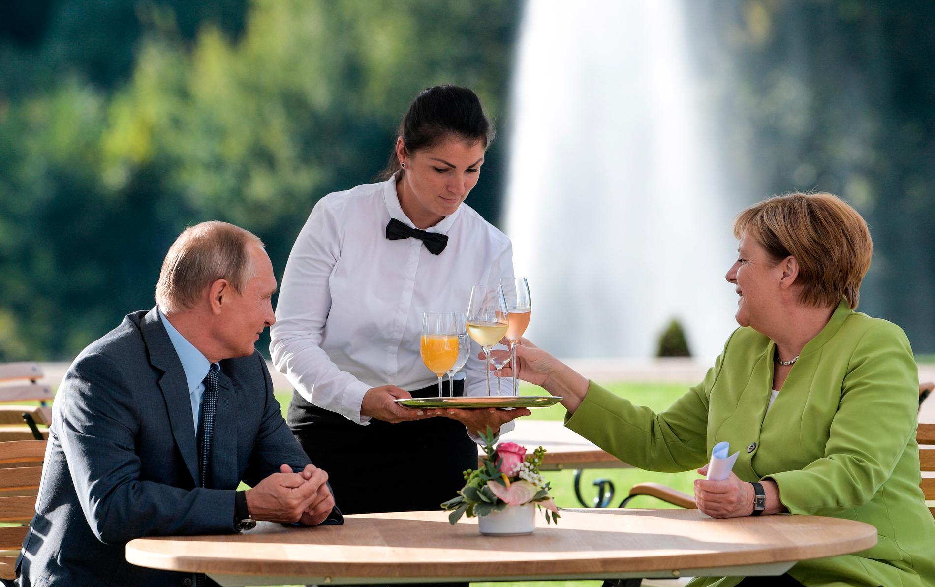 Vladimir Putin och Angela Merkel serveras förfriskningar under mötet vid slottet Meseberg utanför Berlin.