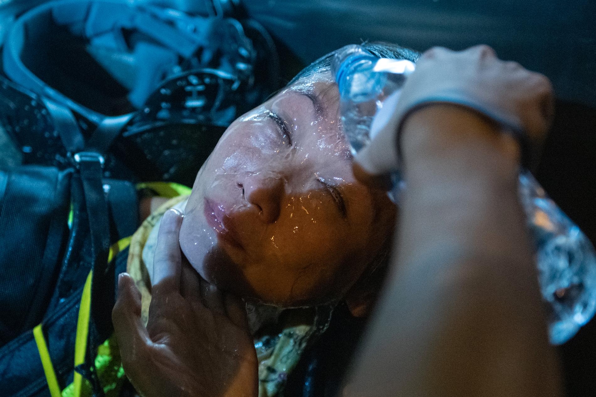 En demonstrant får ansiktet sköljt med vatten efter att ha träffats av tårgas.