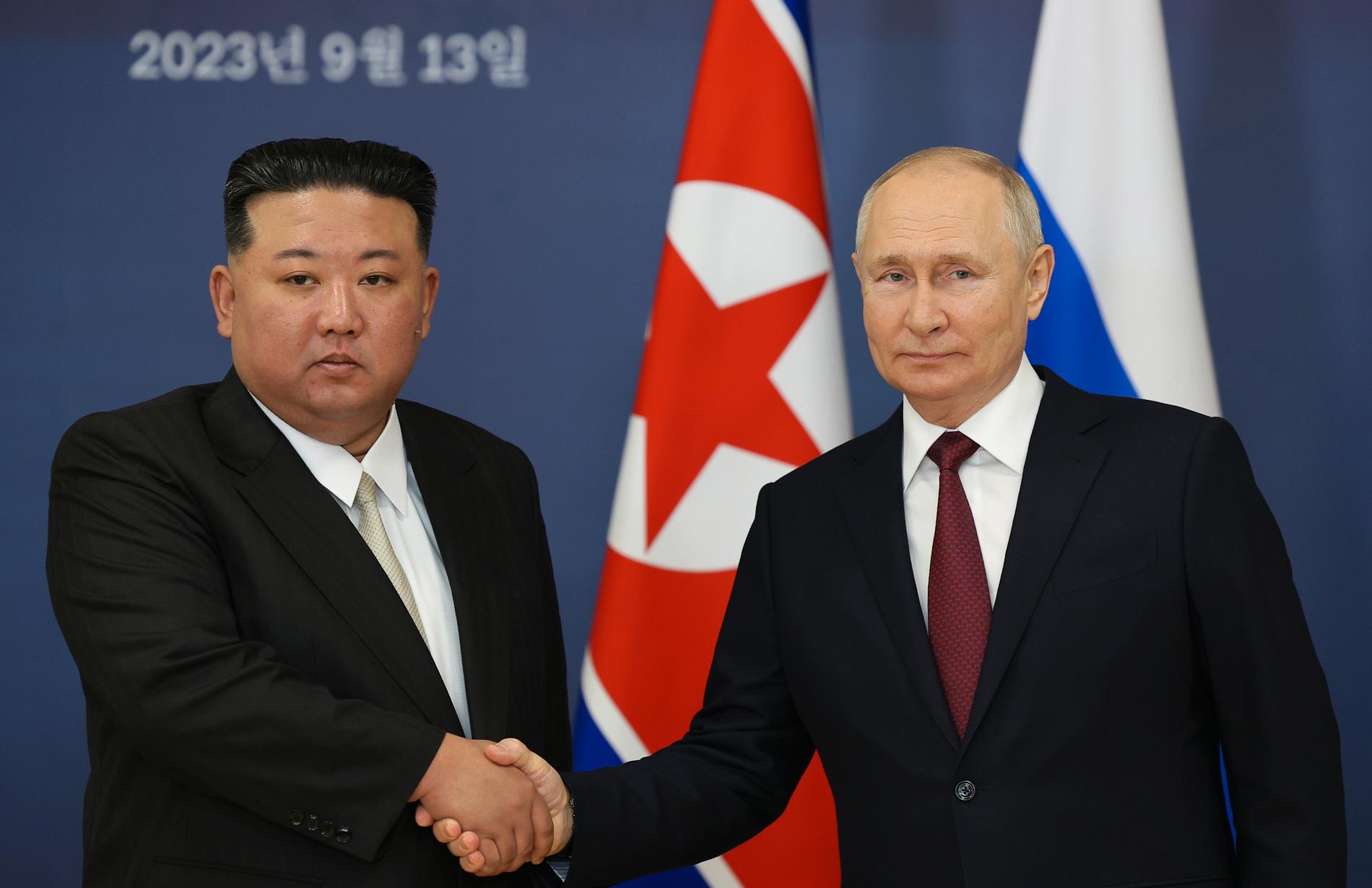 Vladimir Putin och Kim Jong Un skakar hand under mötet. 
