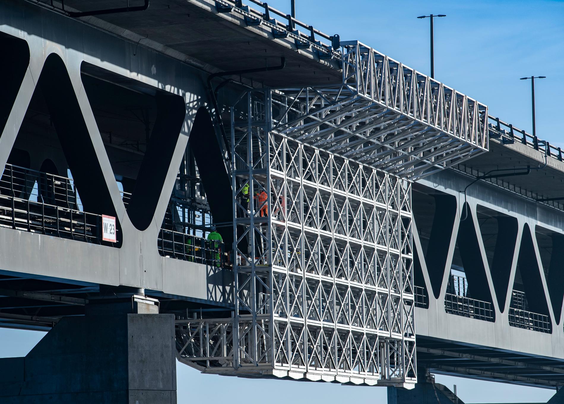 Den specialbyggda målningsplattformen har Öresundsbrons tågdäck på ena sidan och Öresund på den andra.