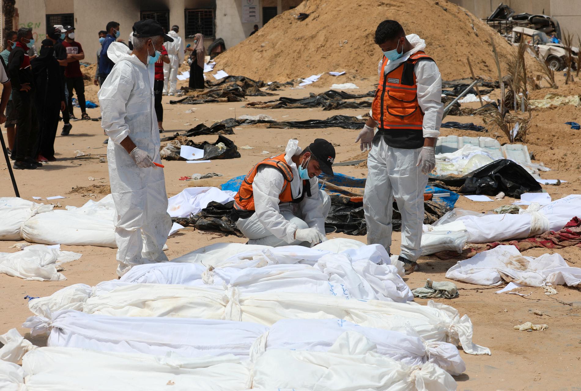 Personer som arbetar med att flytta de upphittade kropparna vid Nassersjukhuset till riktiga gravplatser.