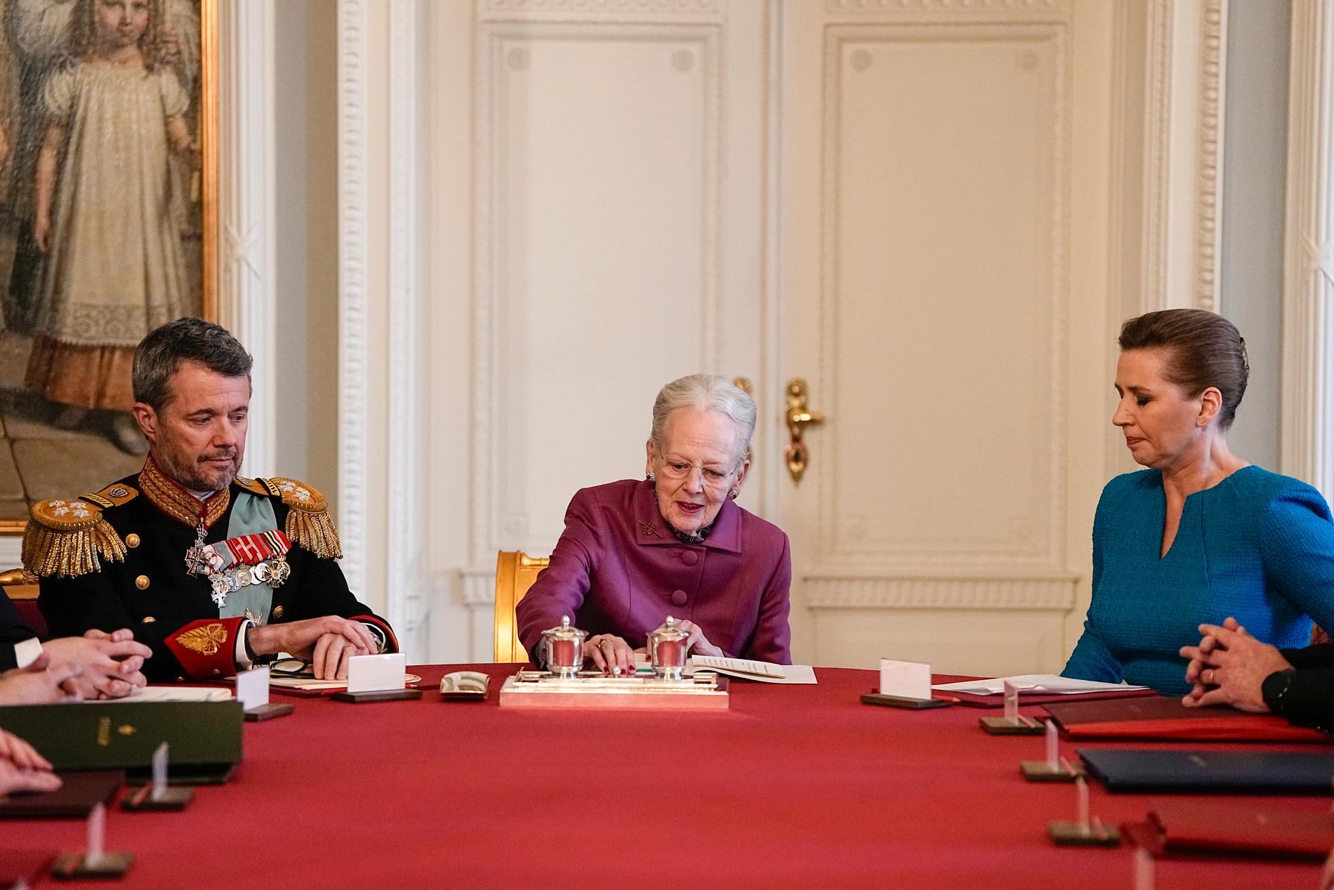 Drottning Margrethe skriver under sin abdikering. Till vänster den nya kungen Frederik och till höger statsminister Mette Frederiksen.