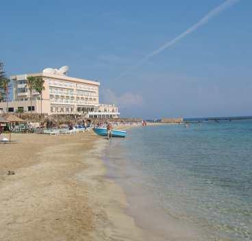 Turister hittar fortfarande till stranden i Famagusta, men det är inte många som förr.