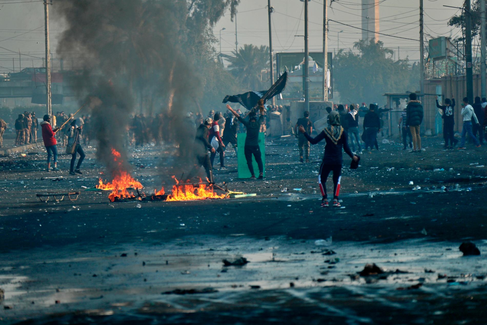 Regeringsfientliga demonstranter under drabbningar med säkerhetsstyrkor i Iraks huvudstad Bagdad på måndagen.