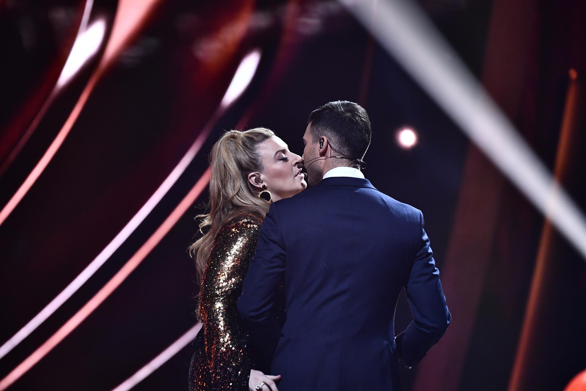 Sarah Dawn Finer passar på att stjäla en kyss av Eric Saade i finalen av Melodifestivalen 2019.
