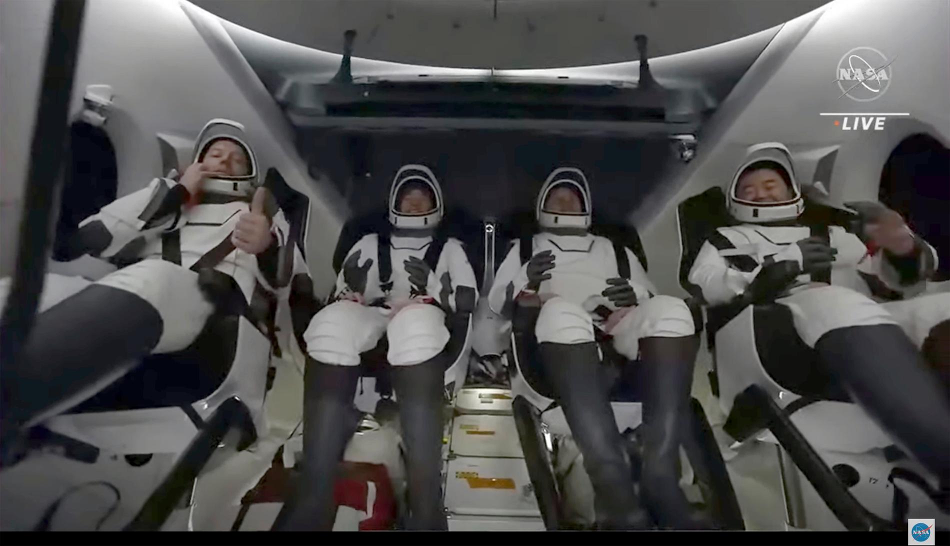 De fyra återvändande astronauterna i sin kapsel på väg mot jorden.