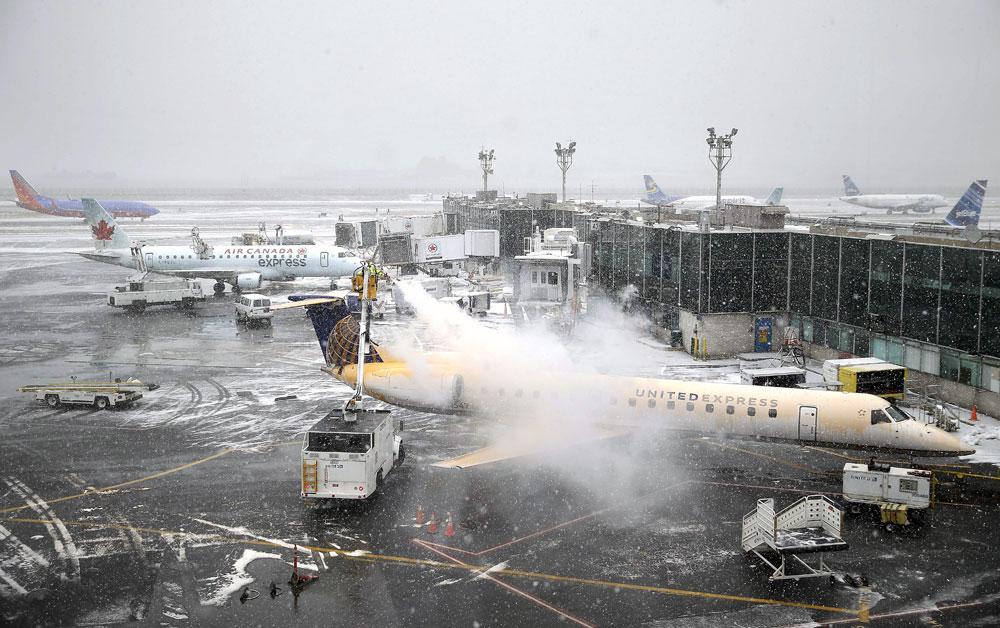 Ett plan på flygplatsen La Guardia behandlas mot isbeläggning den 26 januari i år. Tusentals flyg ställdes in den dagen – men Norwegian flög med bantad besättning.