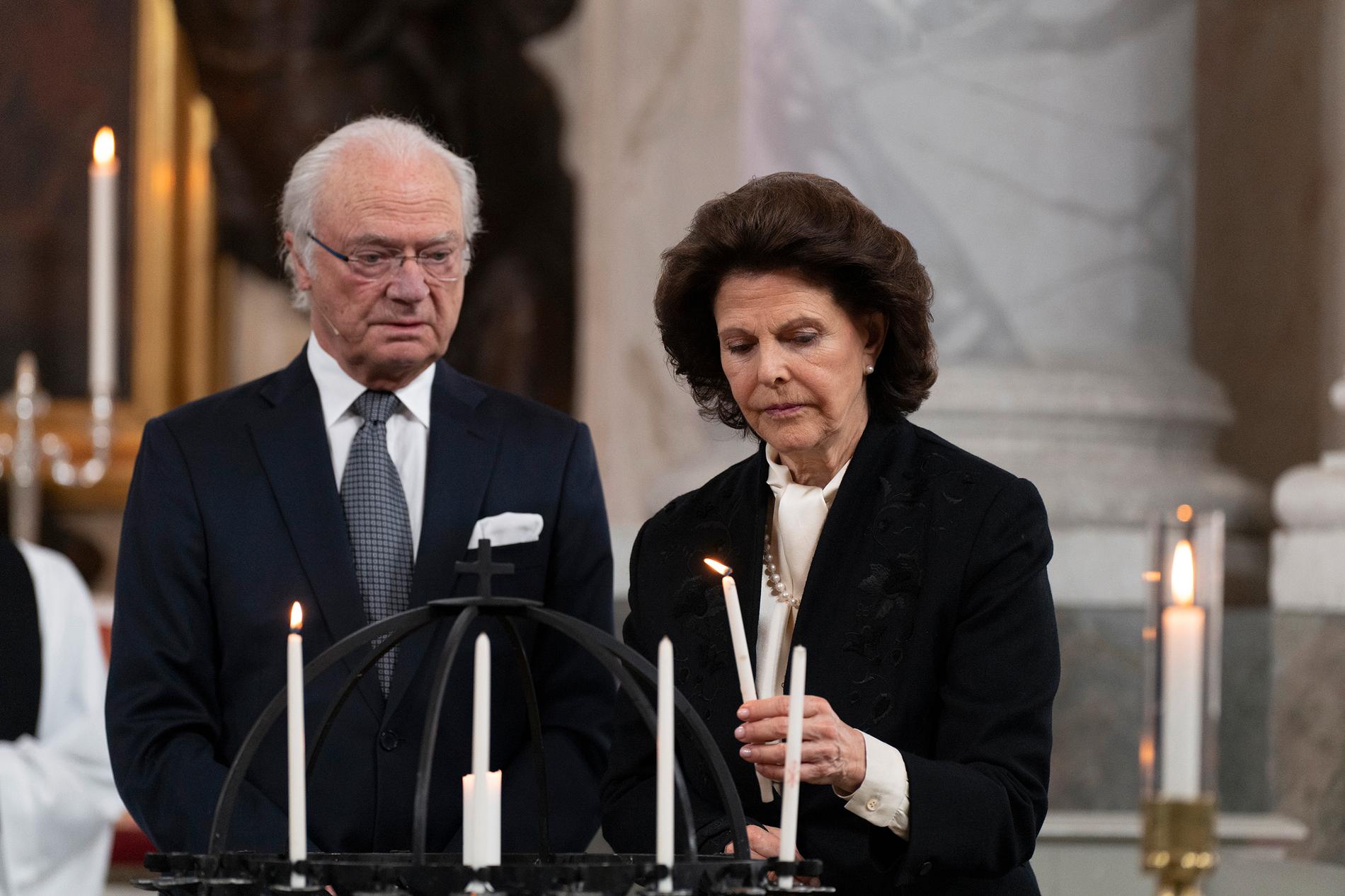 Kung Carl Gustaf och drottning Silvia tänder ljus under en gudstjänst i Drottningholms slottskyrka.