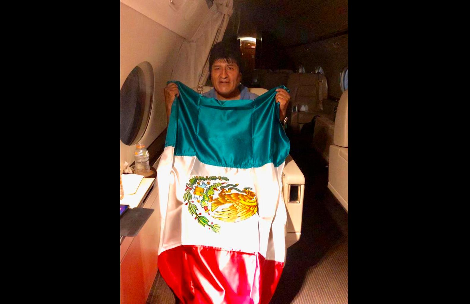 Evo Morales med en mexikansk flagga ombord på ett plan som ska ta honom till Mexiko. Bilden släpptes av den mexikanske utrikesministern Marcelo Ebrard.