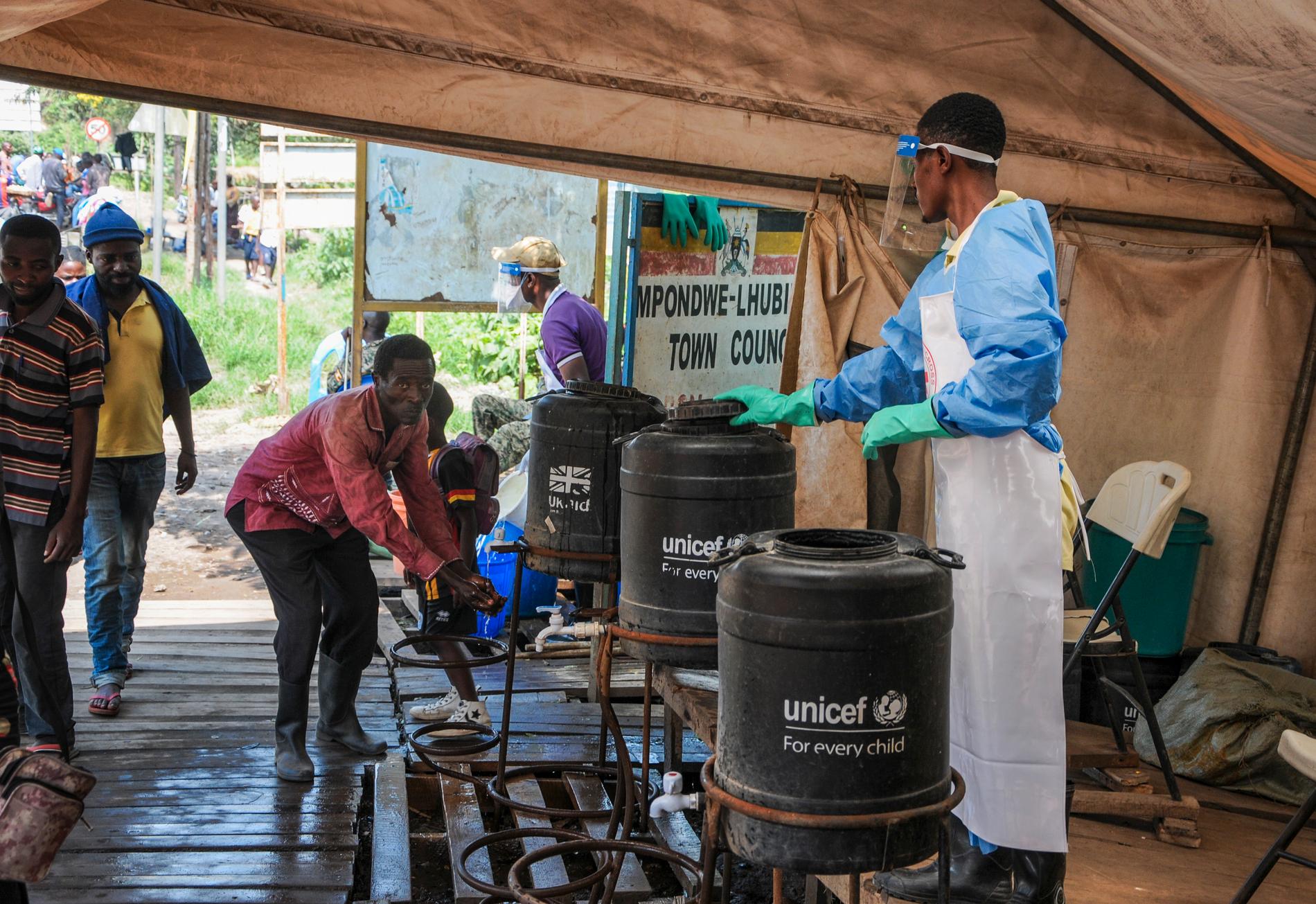 Människor som går över gränsen mellan Kongo-Kinshasa och Uganda manas tvätta händerna i klorerat vatten för att stoppa spridningen av den fruktade sjukdomen ebola.