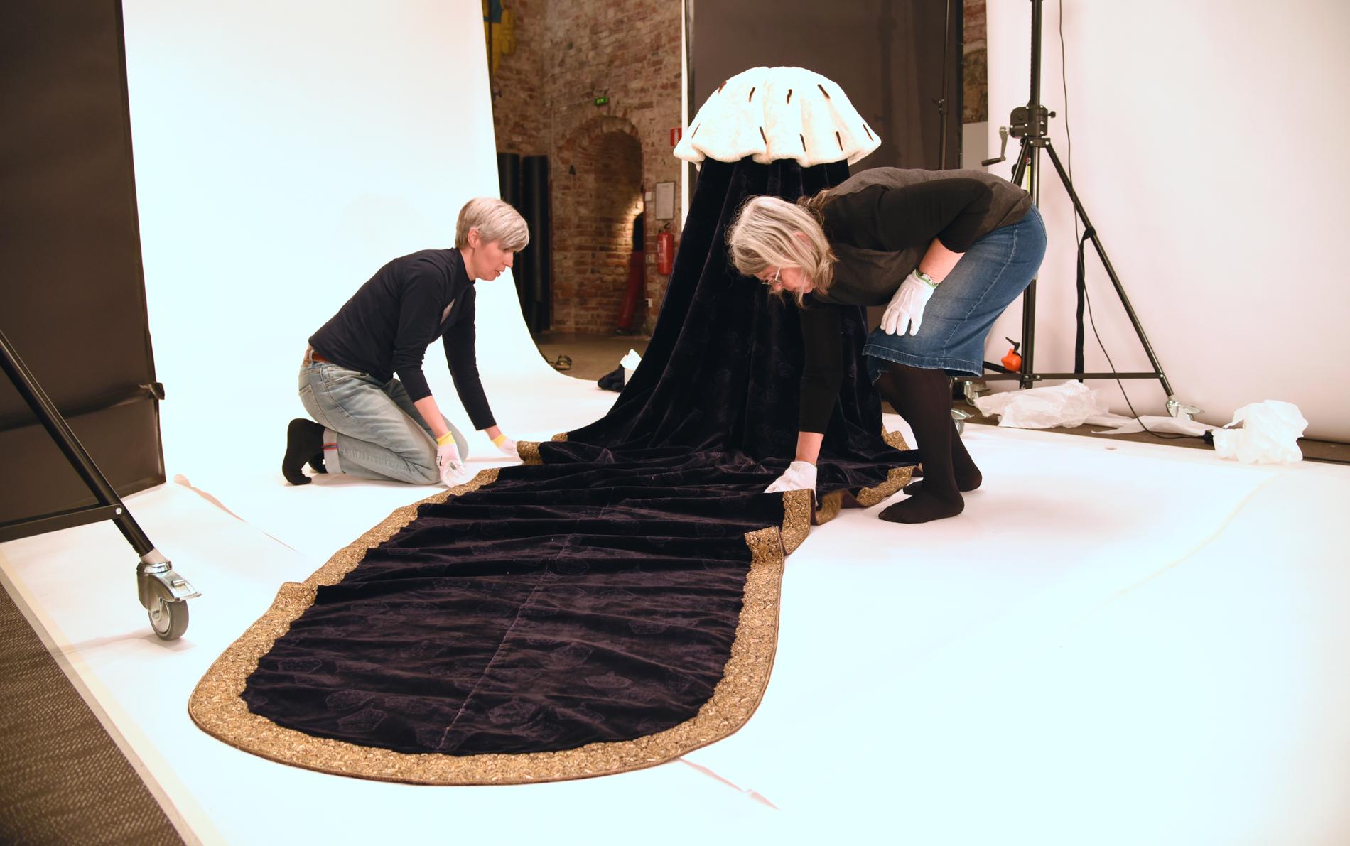 Ett av Sveriges äldsta museer, Livrustkammaren, nyöppnar med en helt ny basutställning den 17 juni. Textilkonservatorerna Augusta Persson och Annika ten Siethoff Wallebring förbereder drottning Kristinas kröningsmantel från 1650 för fotografering.