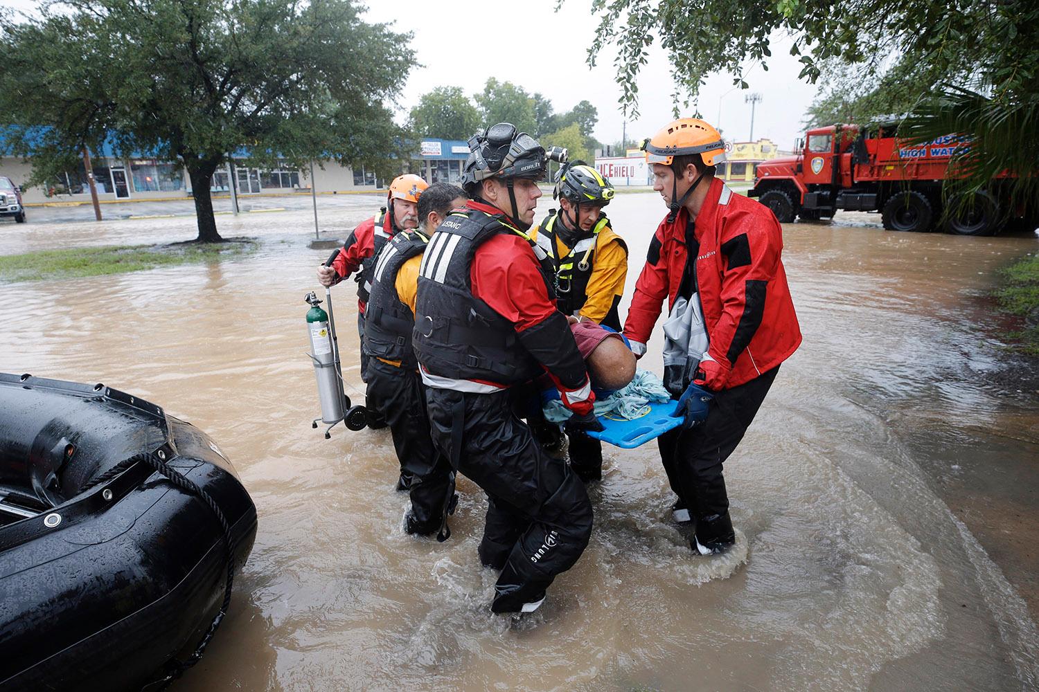 Räddningstjänsten i Houston hjälper en äldre man att komma bort från översvämmningarna.