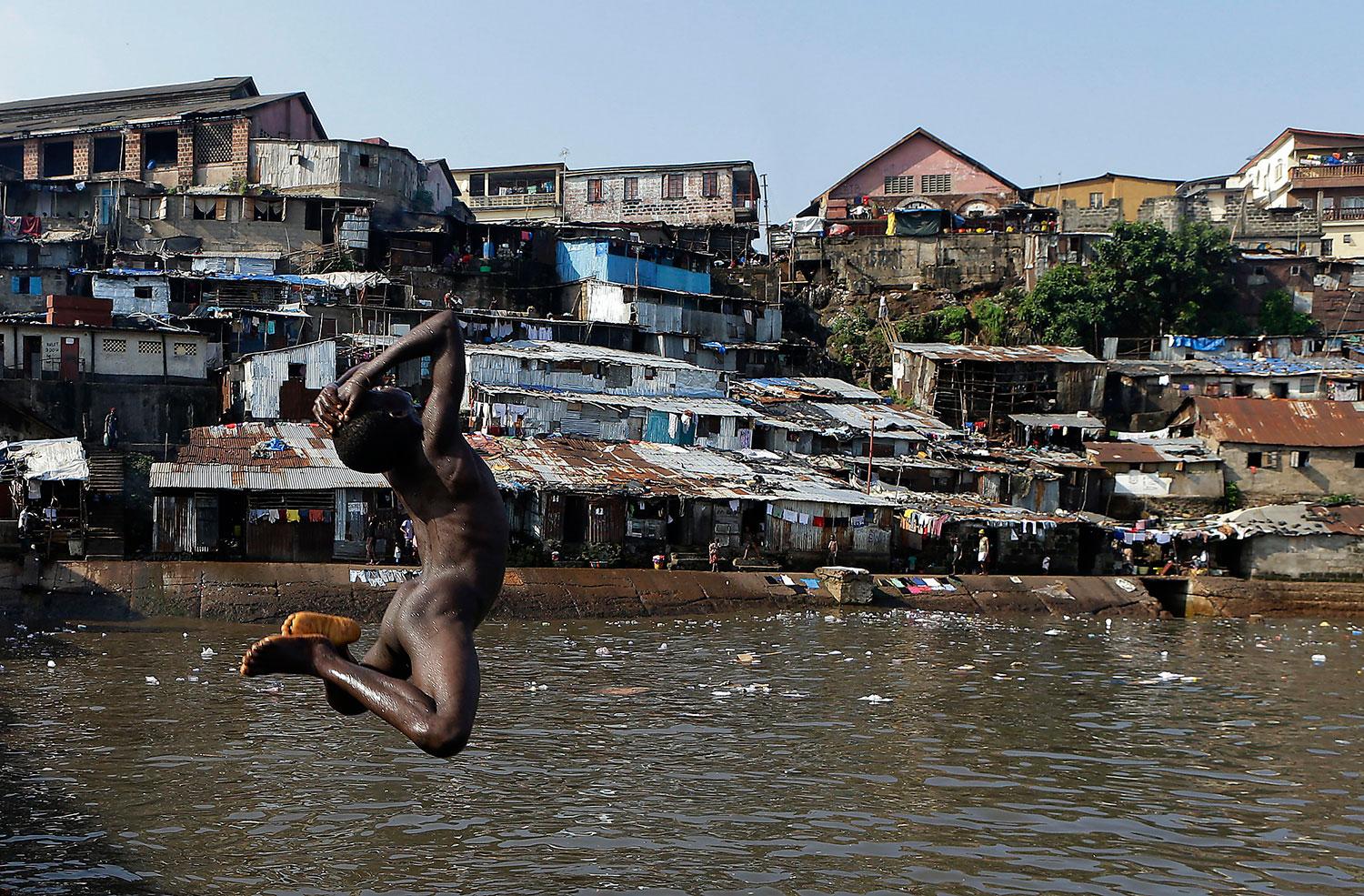 9. SIERRA LEONE Ett svalkande bad i Freetowns slumkvarter, Sierra Leone.