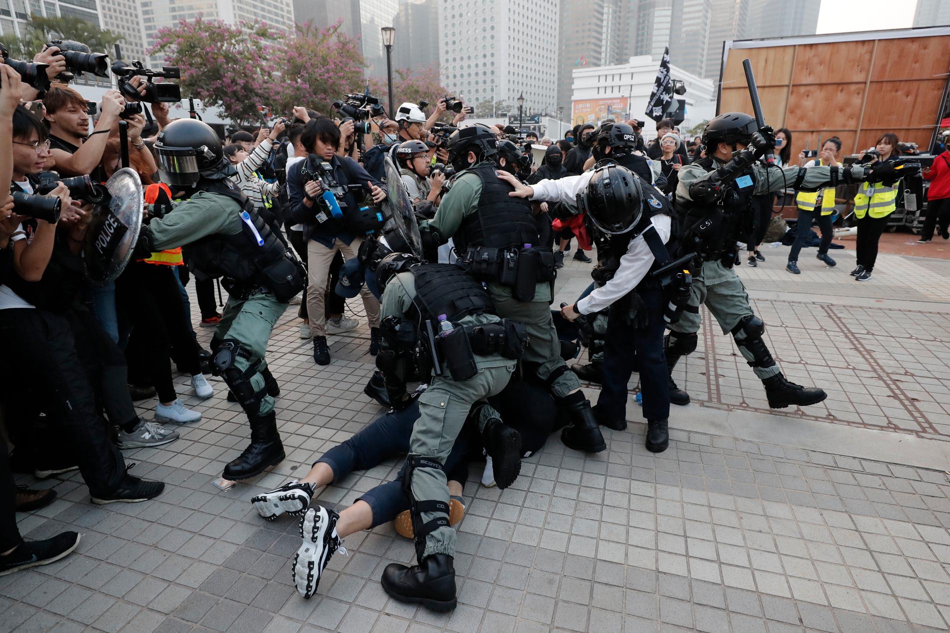 Kravallpoliser ingriper vid demonstrationen i Hongkong.