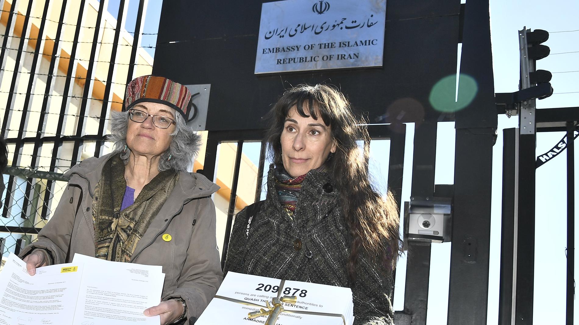 Andrea Bodekull och Maja Åberg, båda Amnesty, framför grinden till Irans Ambassad med namnunderskrifter. Arkvibild.