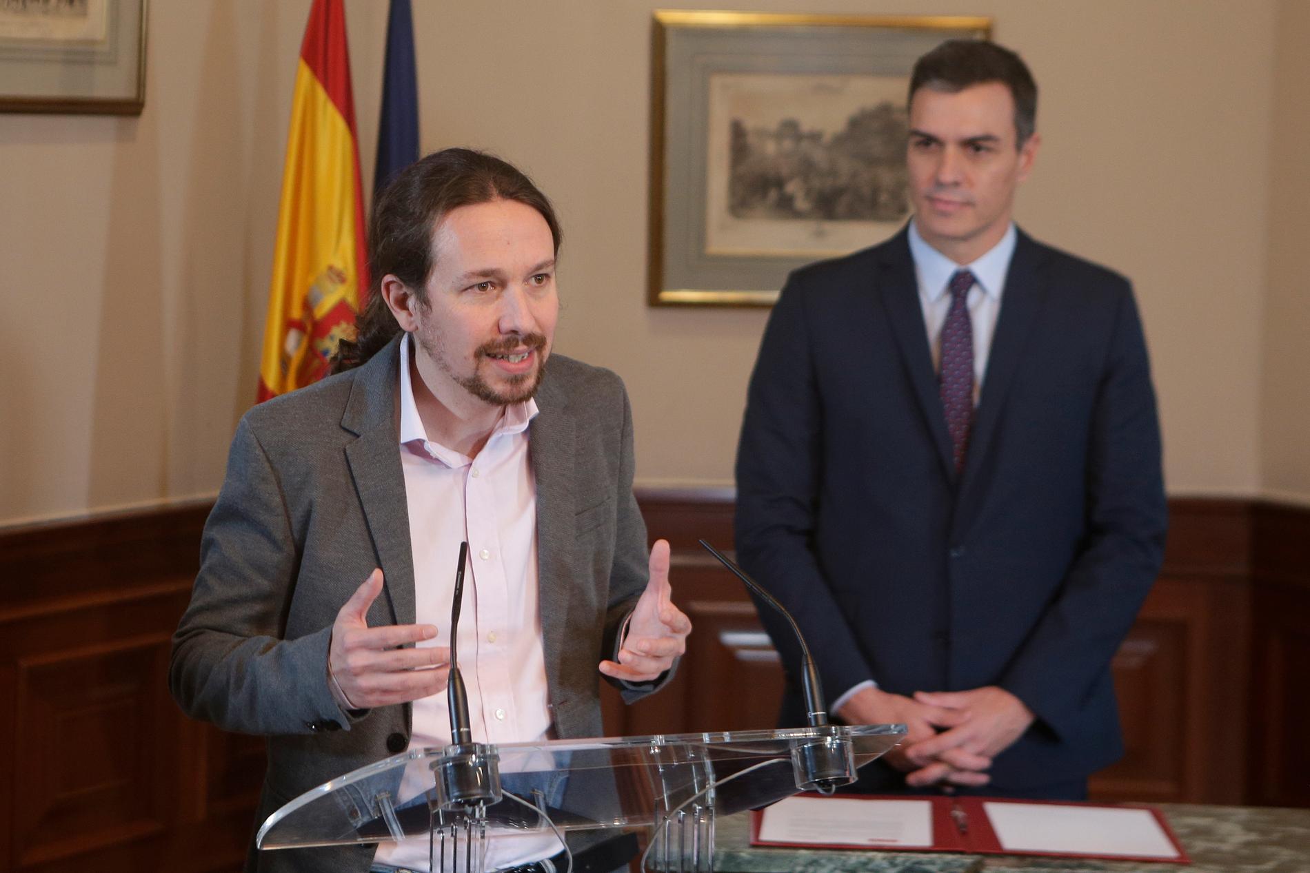Unidas Podemos-ledaren Pablo Iglesias kallar vänsterpakten "ett vaccin mot extremhögern". Tillförordnade premiärministern Pedro Sánchez lyssnar.