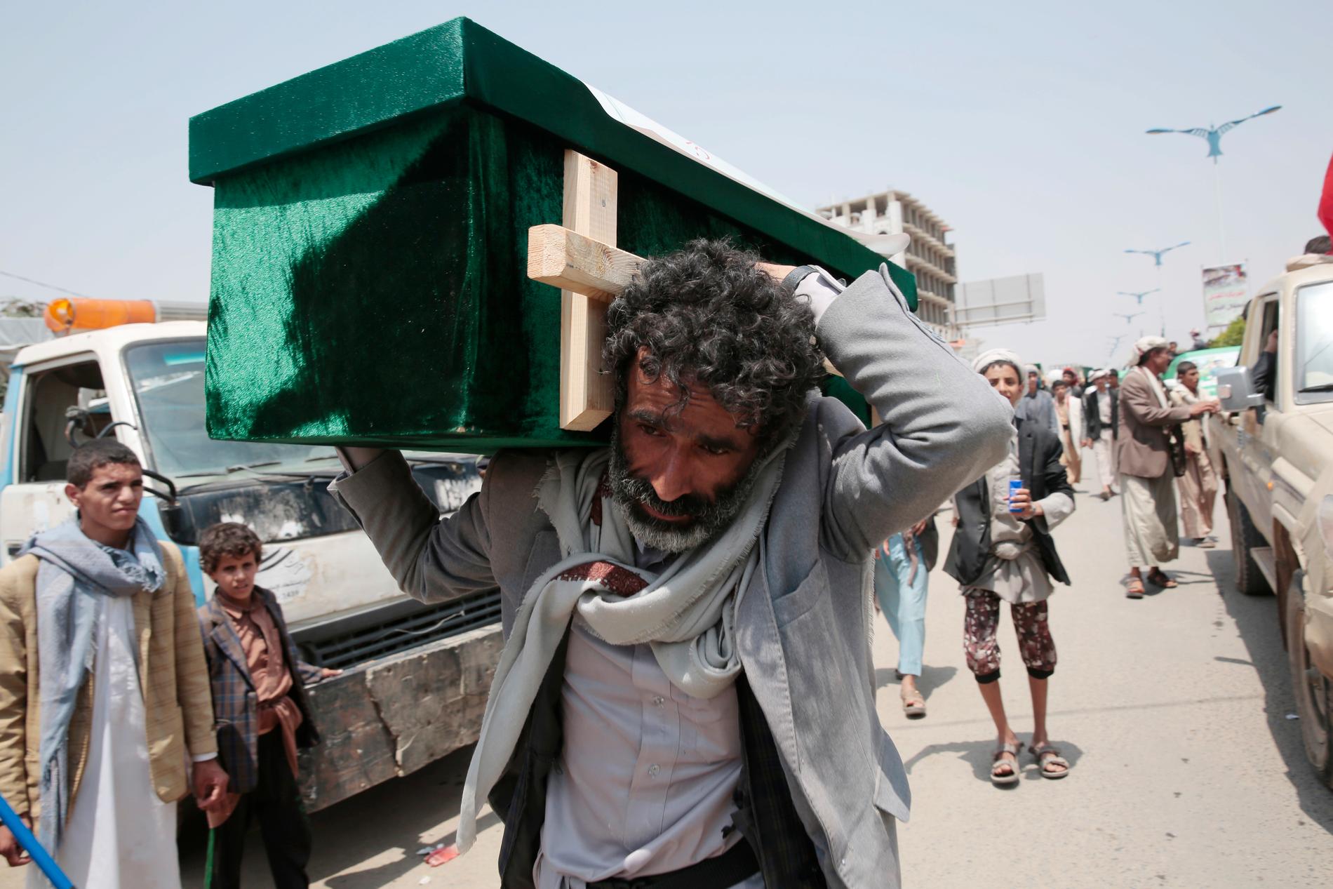 En jemenitisk man bär en kista med ett av offren för en flygattack mot norra Jemen, utförd av den saudiskledda alliansen. Tiotals människor dödades i attacken, som fick FN att kräva en utredning. Bilden är från 13 augusti i år.
