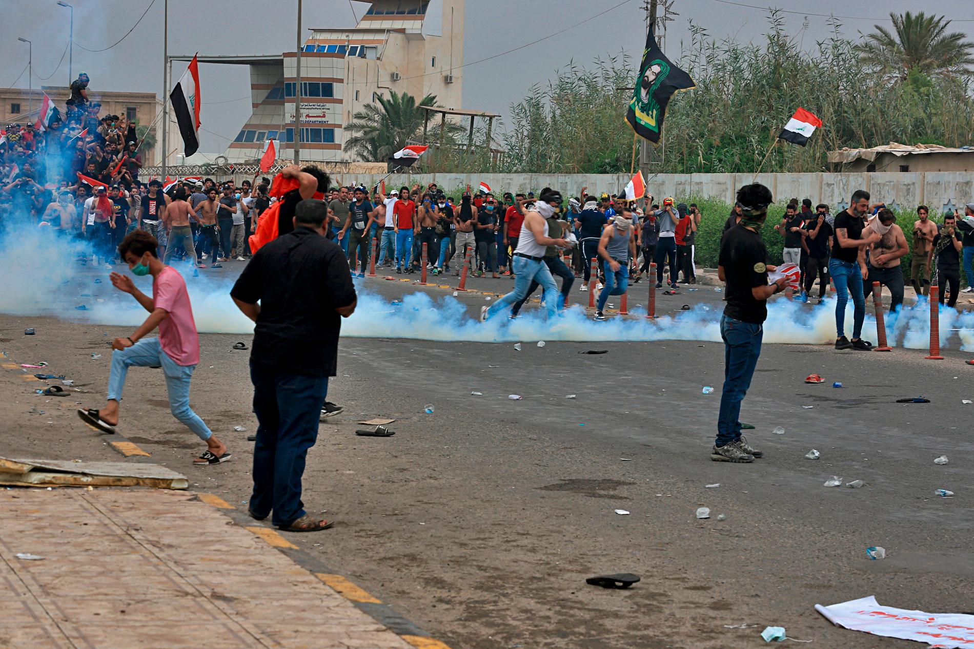 Irakisk säkerhetspolis använder tårgas mot demonstranter i Basra den 25 oktober.