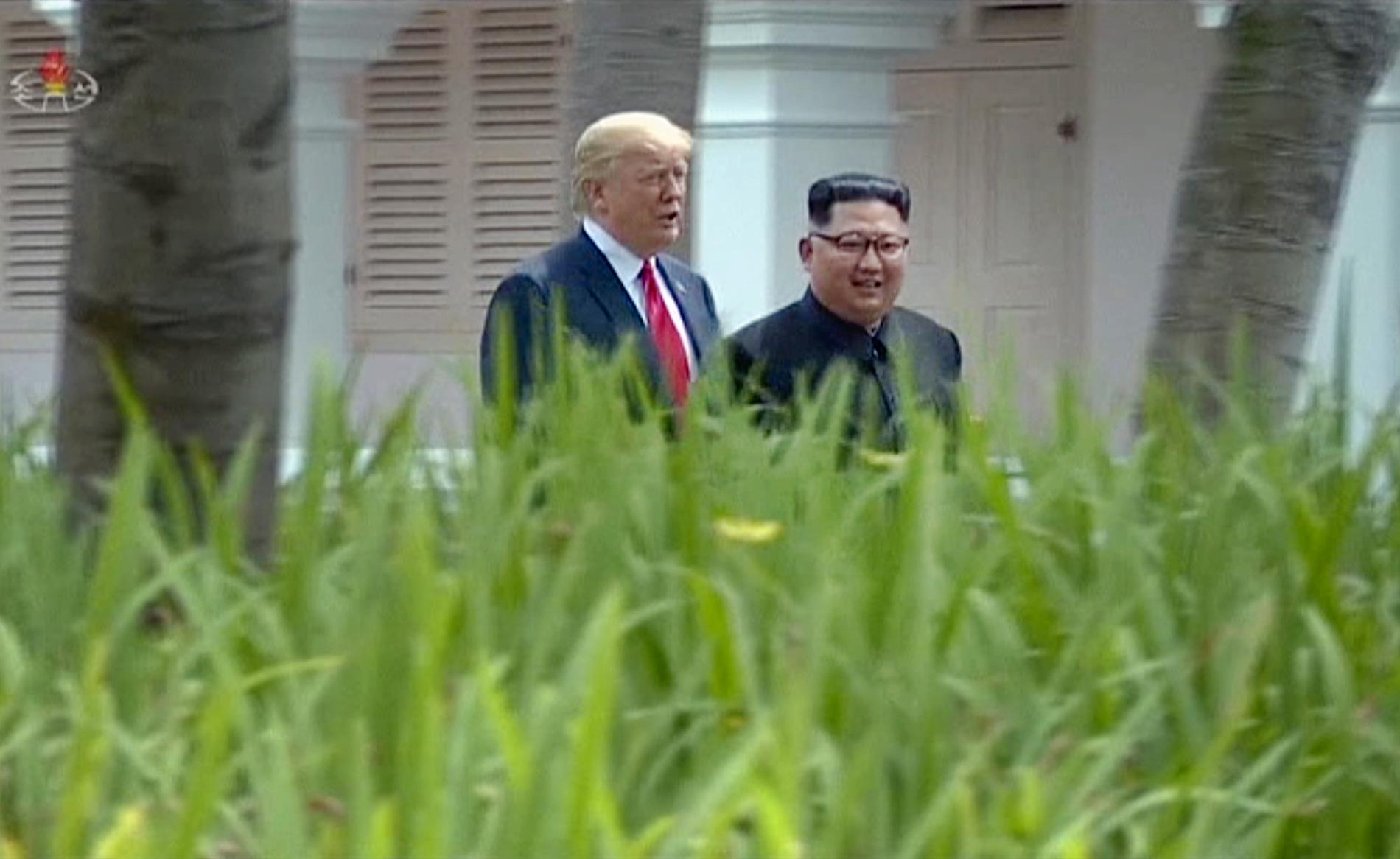 USA:s president Donald Trump och Nordkoreas ledare Kim Jong-Un promenerar tillsammans vid toppmötet i Singapore i fjol. Bilden släpptes av det nordkoreanska tv-bolaget KRT i juni 2018.