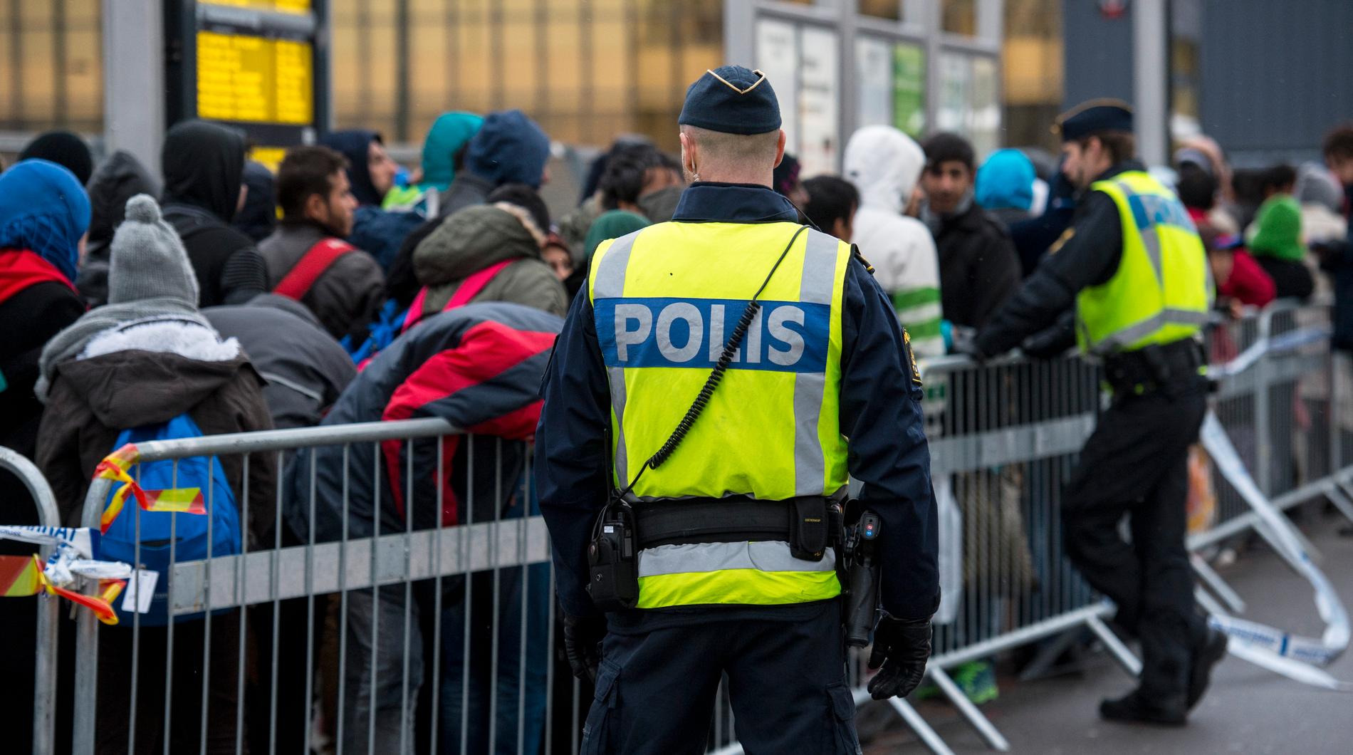 Poliser övervakar kö av ankommande flyktingar vid Hyllie station i Malmö hösten 2015. Arkivbild.