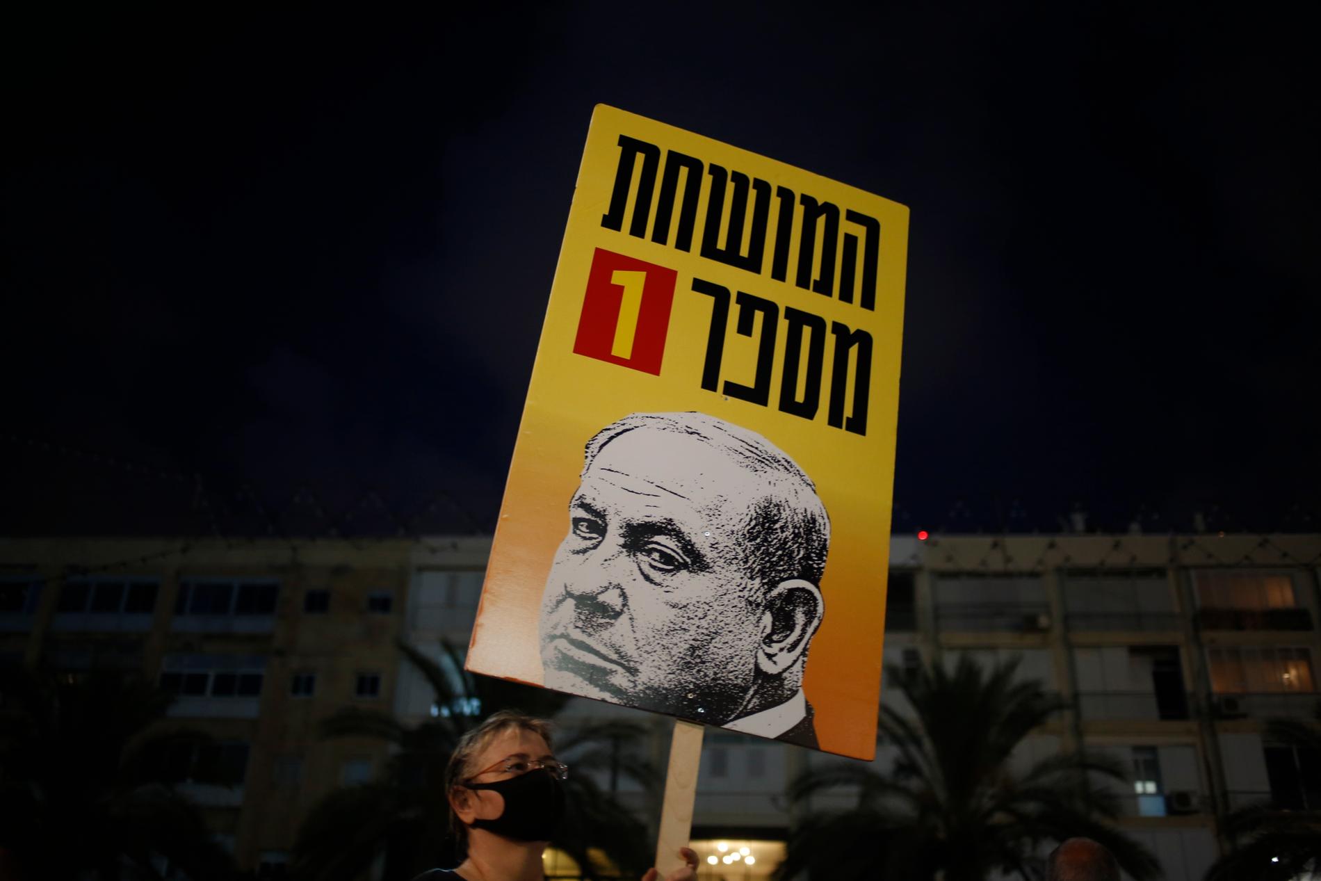 Demonstranter i Tal Aviv i Israel håller upp en plakat en bild på premiärminister Benjamin Netanyahu och texten " Korrumperad person nummer ett". Demonstranterna protesterar mot den israeliska regeringens hantering av coronakrisen.