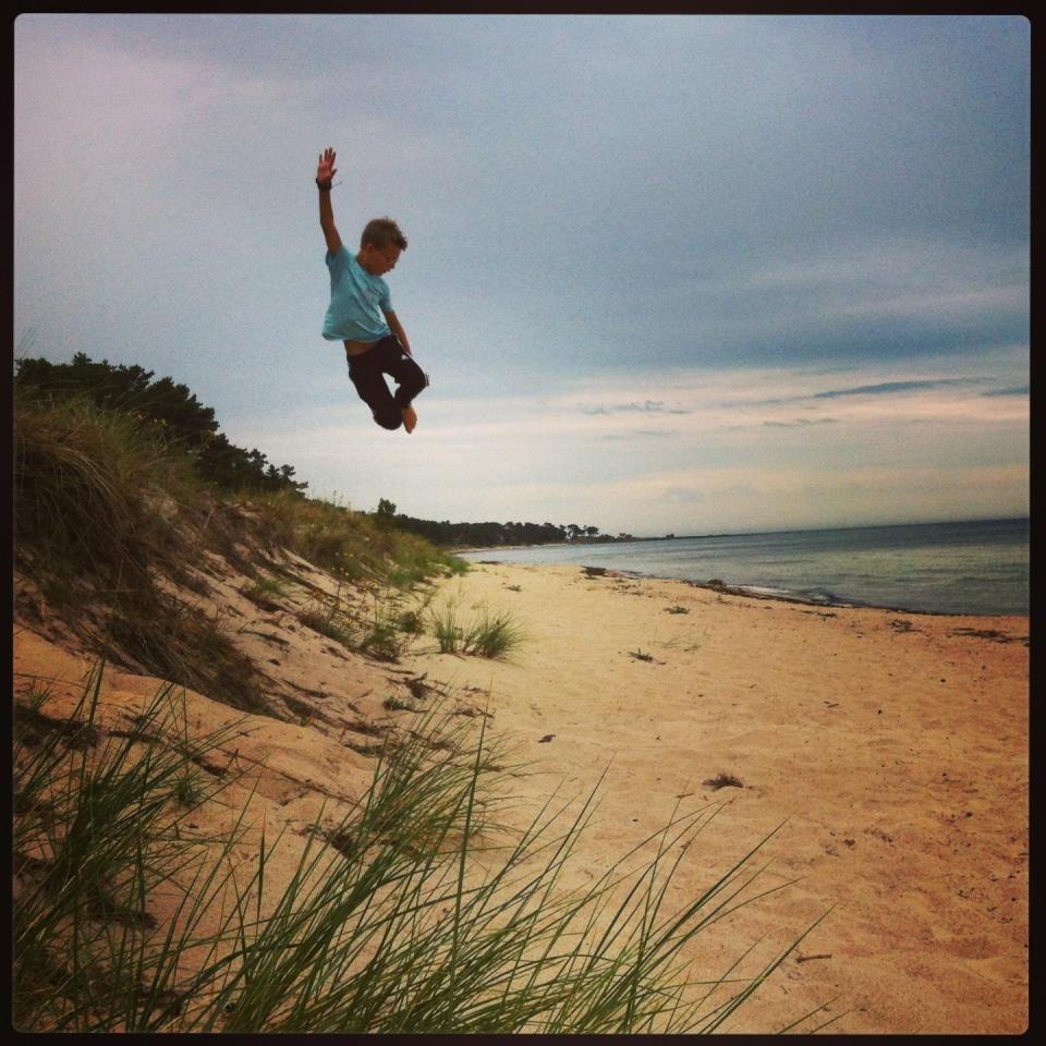Ludvig 8 år roar sig denna regniga dag på den folktomma stranden i Åhus
