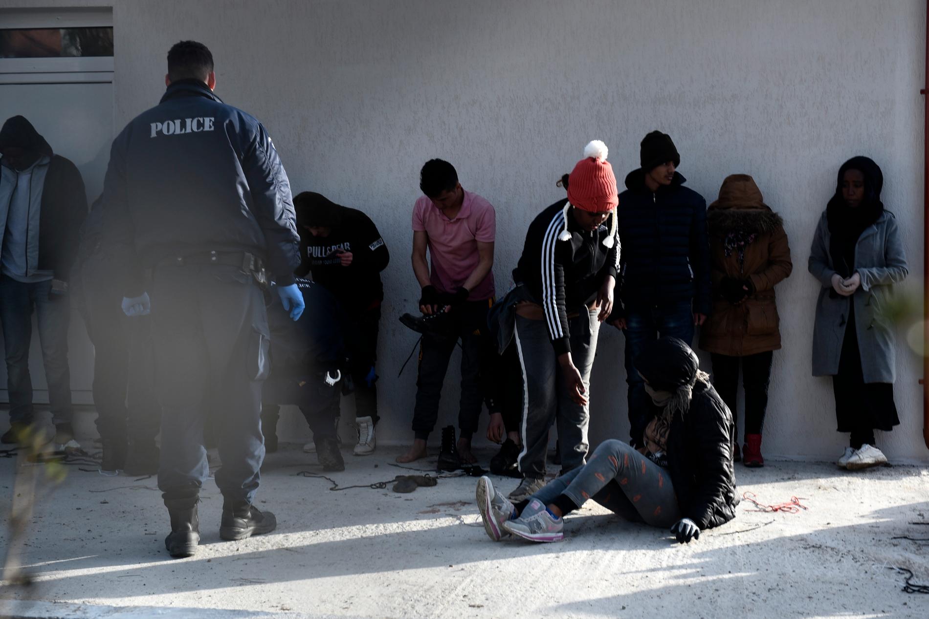 Grekisk polis kontrollerar tillfångatagna flyktingar vid en polisstation i byn Neo Cheimonio.