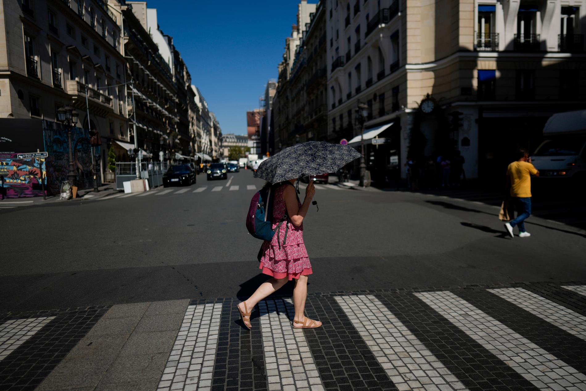 En kvinna skyddar sig från Paris-solen med ett parasoll, 6 september. 