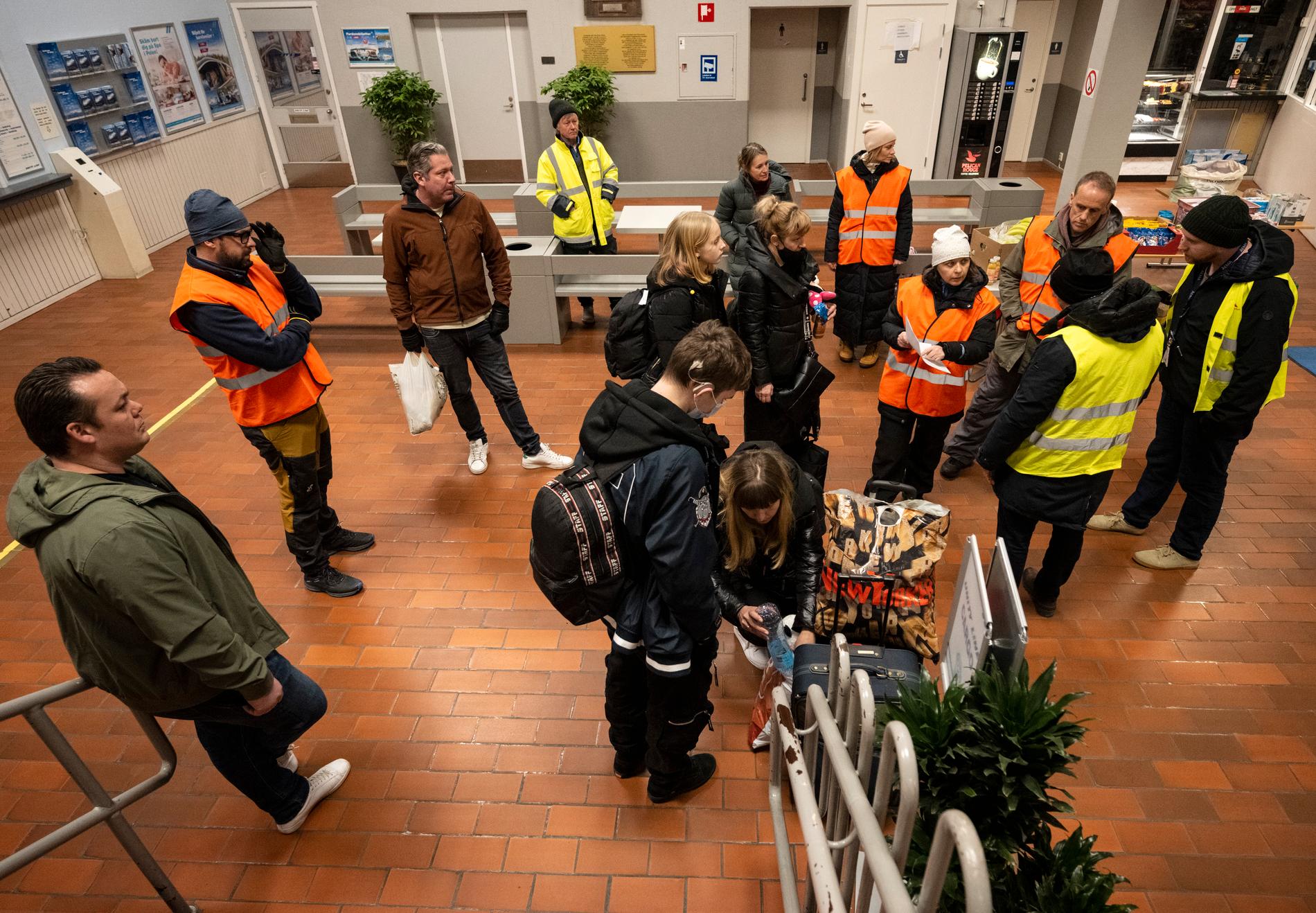 Flyktingar från Ukraina får under lördagen information från Migrationsverket och Refugees Welcome Sweden i färjeterminalen i Ystad.