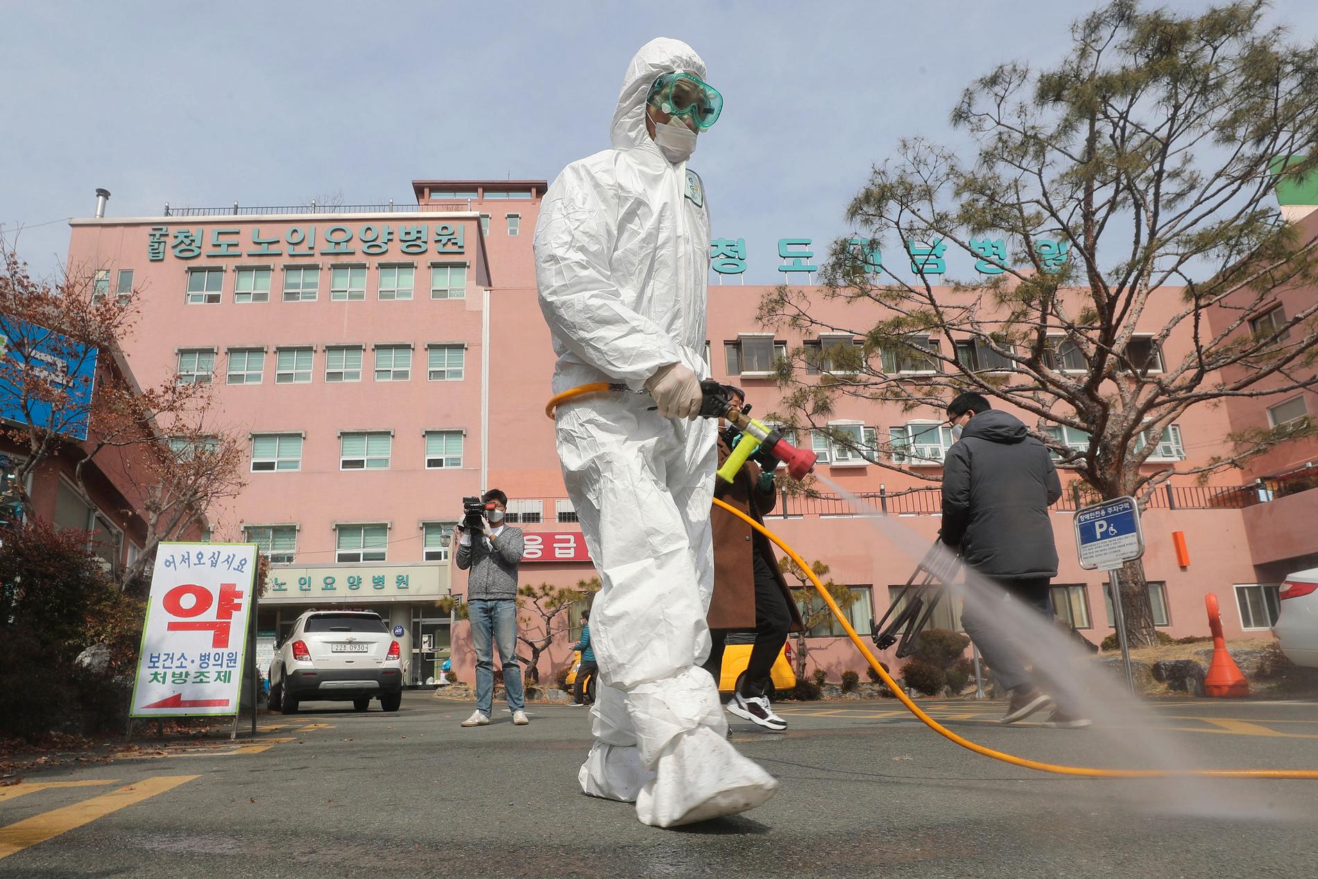 Desinfektionsmedel sprutas på gatan utanför ett sjukhus i Cheongdo i Sydkorea.