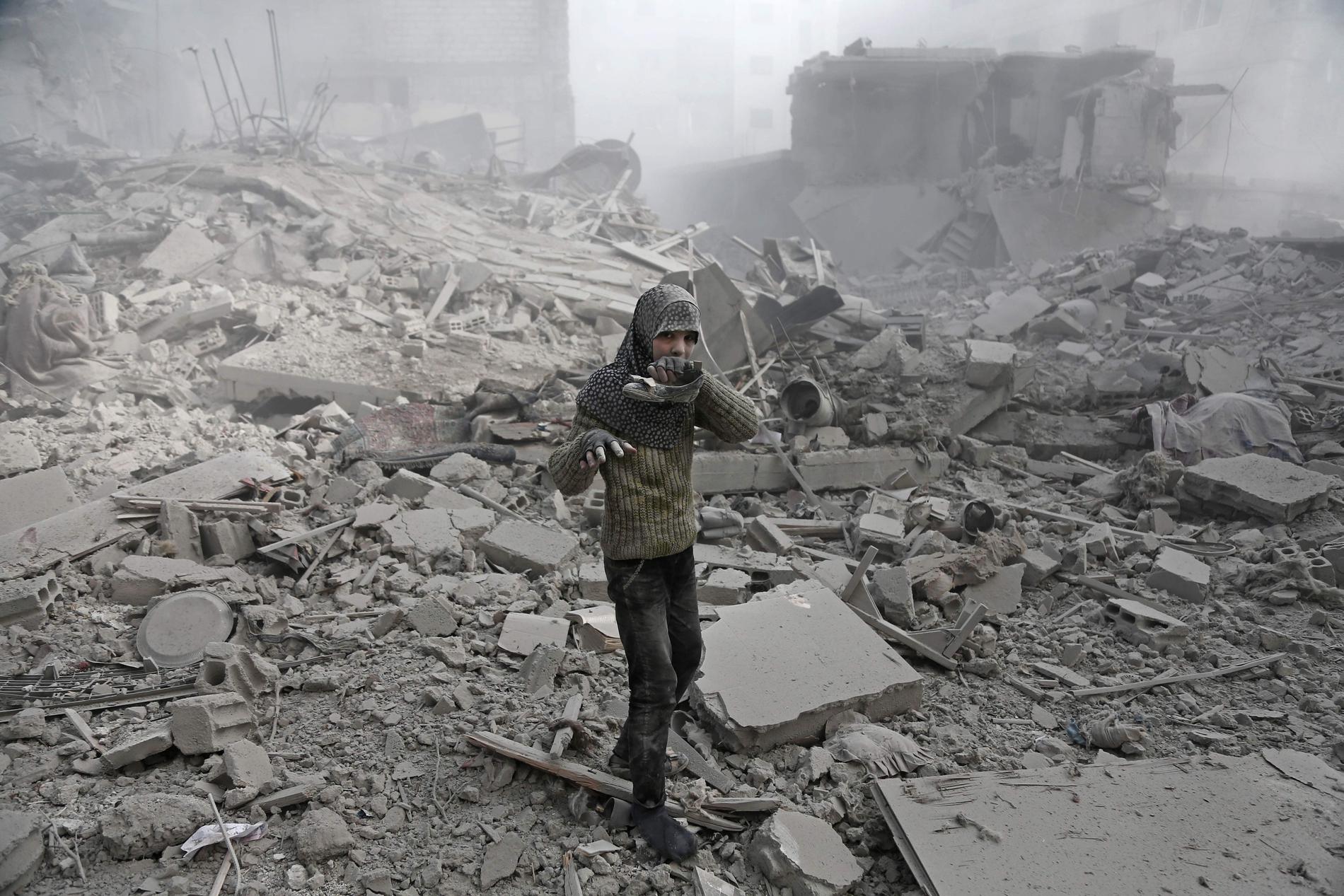En syrisk flicka i förödelsen efter en bombattack i Ghouta