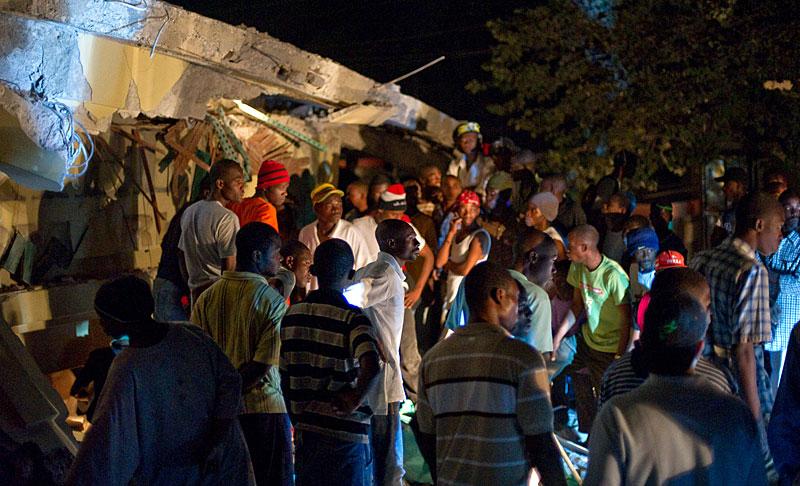 FÅNGADE I AFFÄREN Oroliga haitier samlades vid stormarknaden som rasade i skalvet för att söka sina anhöriga som befaras vara fångar under bråten efter skalvet.