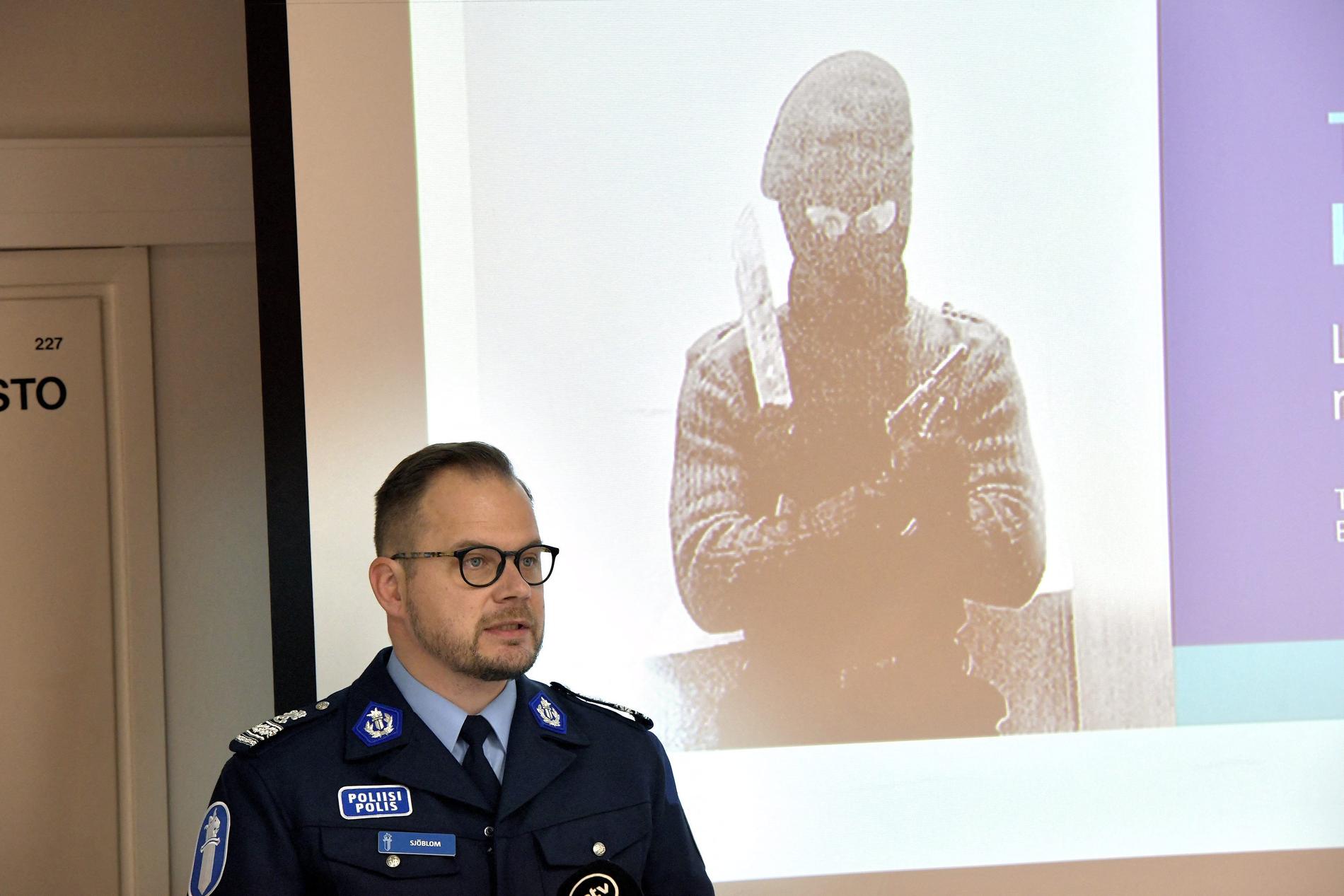 Polisens förundersökningsledare Toni Sjöblom visar en bild som föreställer en av de misstänkta.