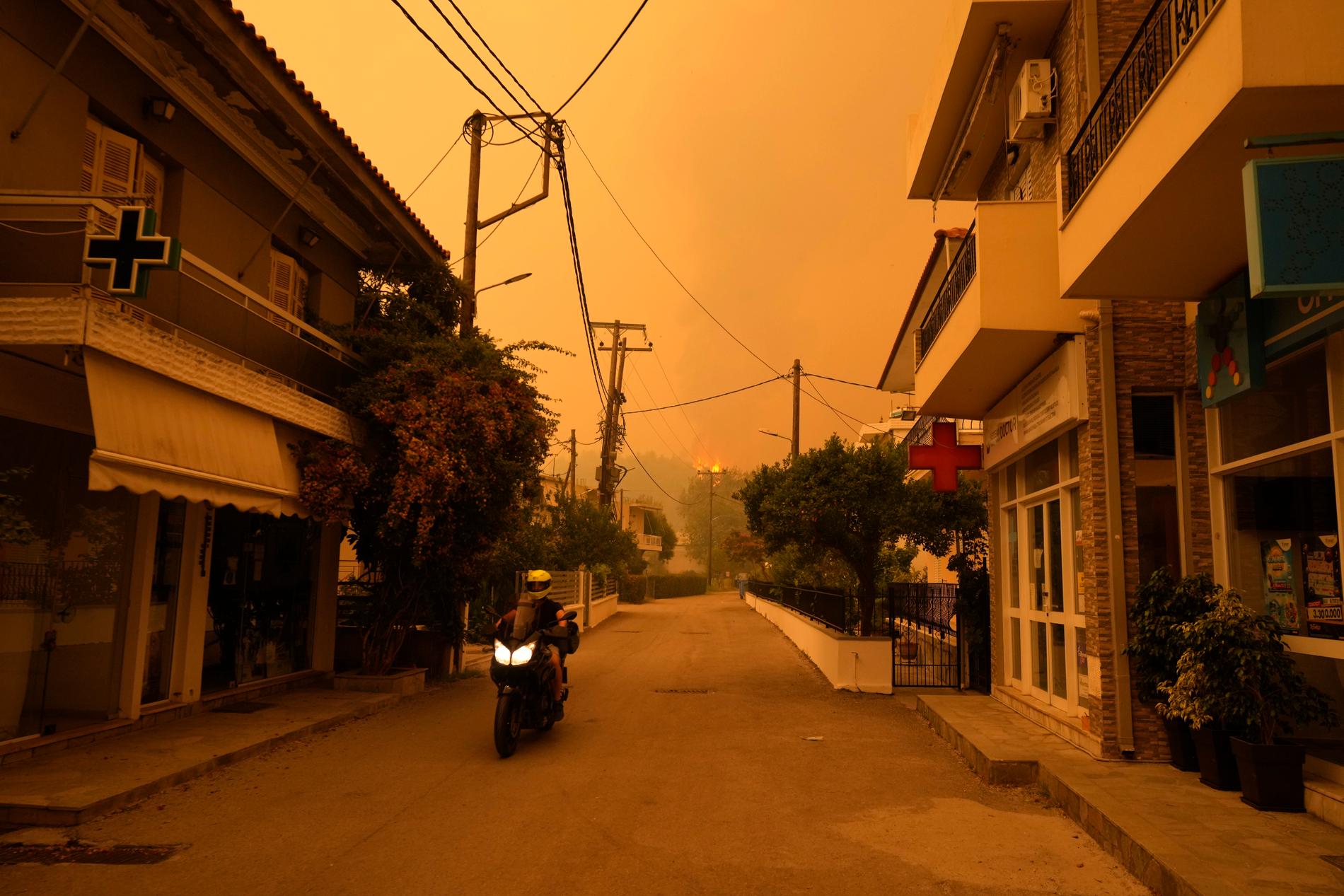Skogsbränder norr om Aten färgade himlen i gula och röda toner under sommaren. Arkivbild.