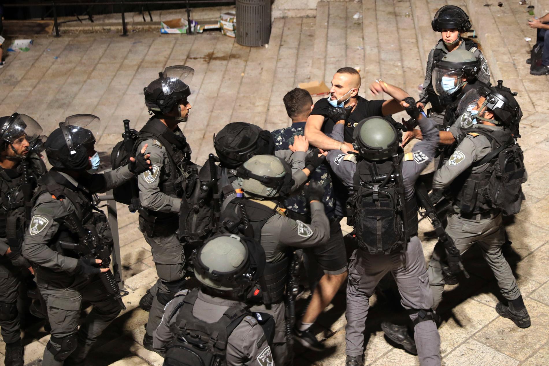 En palestinier stoppas av kravallpolis utanför gamla stan i Jerusalem.