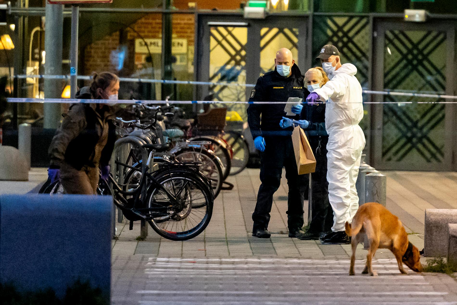 Polisens tekniker och hundpatrull i arbete utanför köpcentret. 