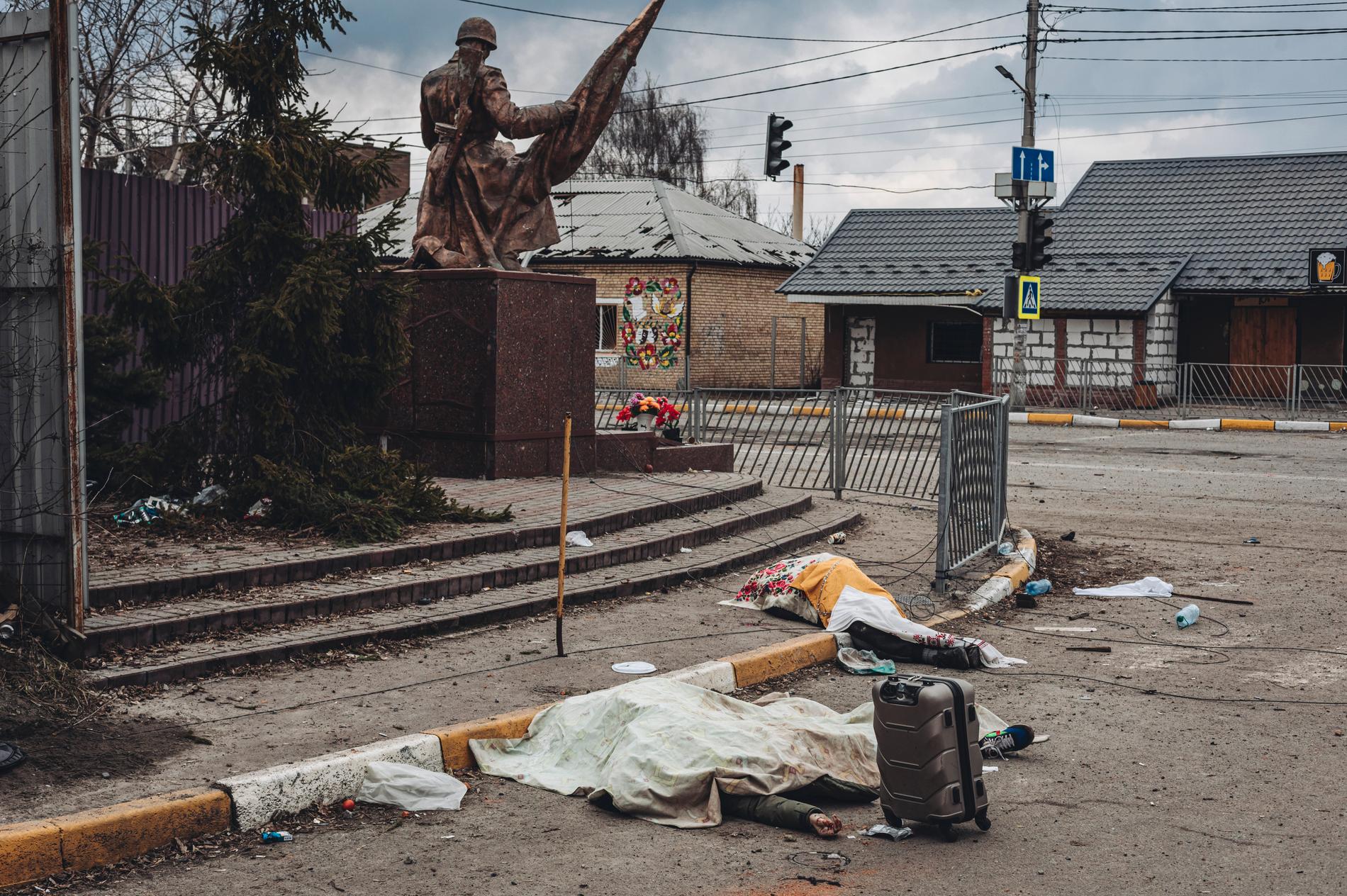 Personer som dödats av rysk beskjutning ligger täckta på gatan i staden Irpin, Ukraina, söndagen den 6 mars 2022.