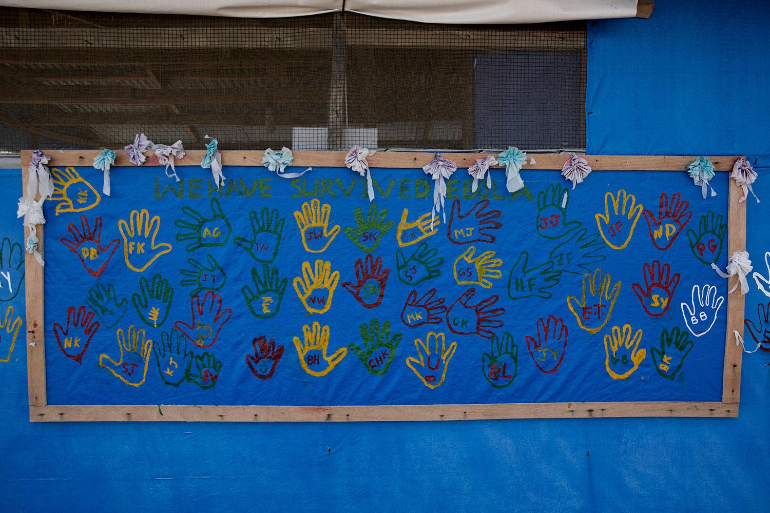 På en vägg till en administrationsbyggnad finns ett 40-tal handavtryck av dem som överlevt ebola.