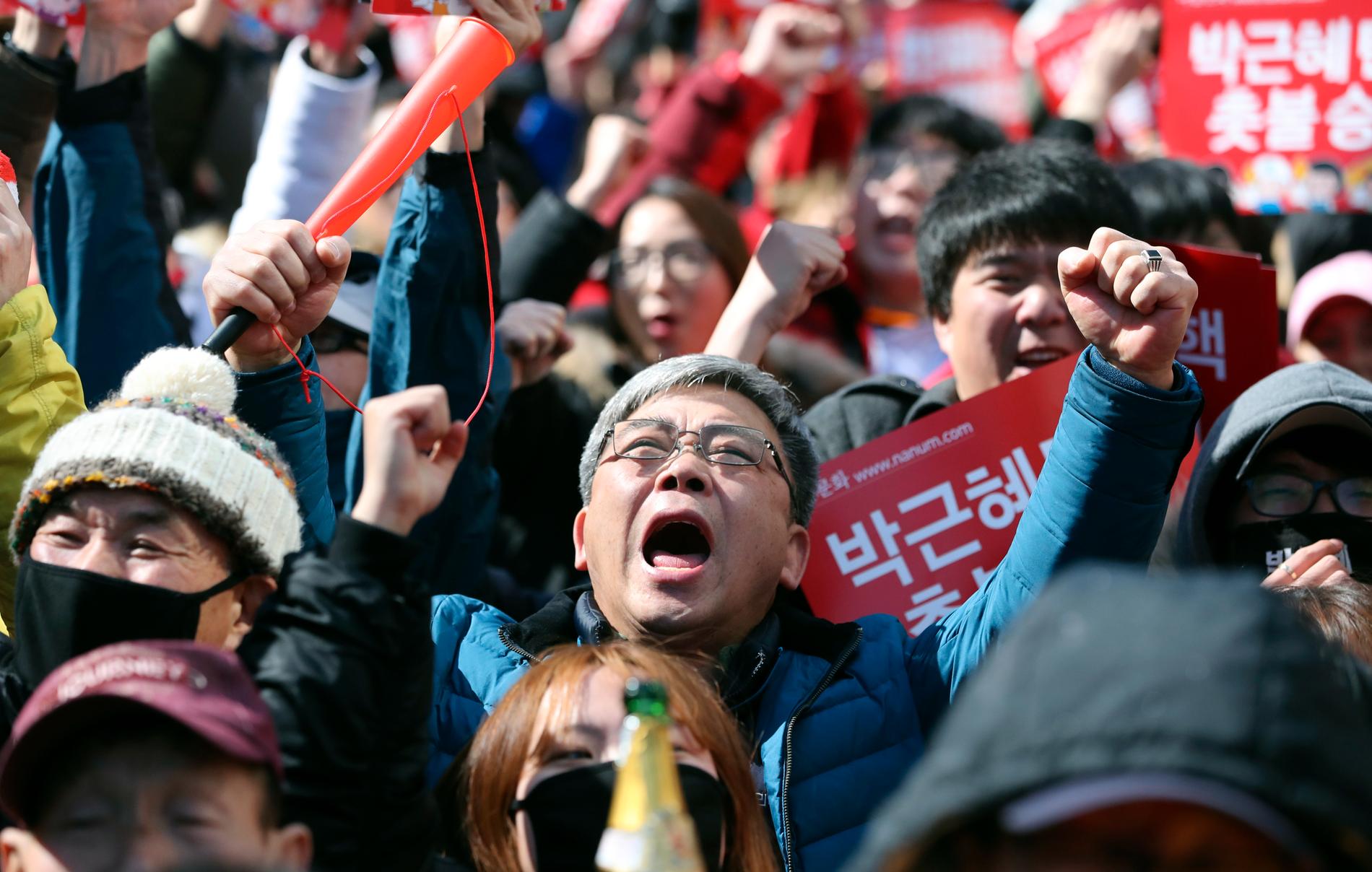 Demonstranter jublar när beskedet om att sydkoreanska president Park Geun-hye tvingas från makten kom på fredagen.