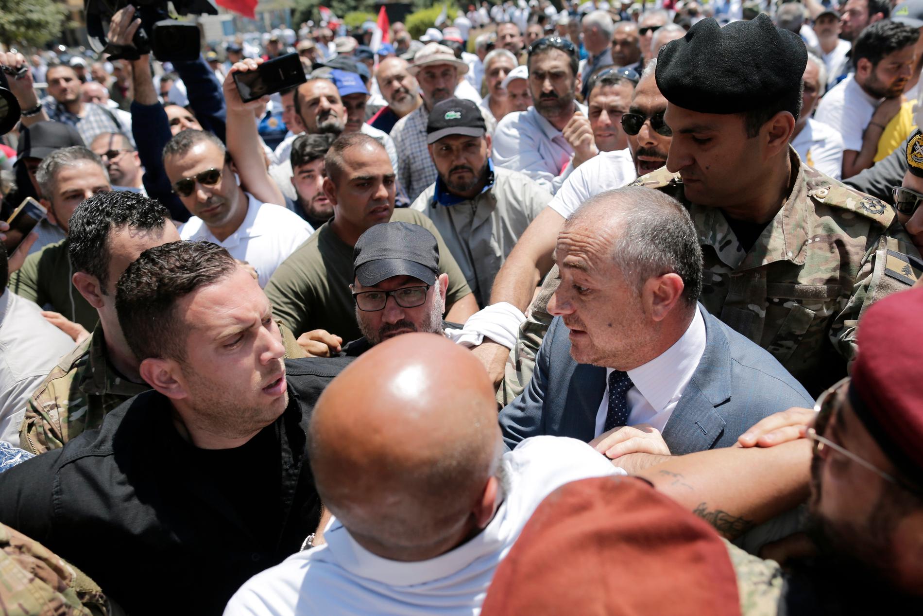 Libanons försvarsminister Elias Bou Saab (till höger) pratar med demonstranter i huvudstaden Beirut.