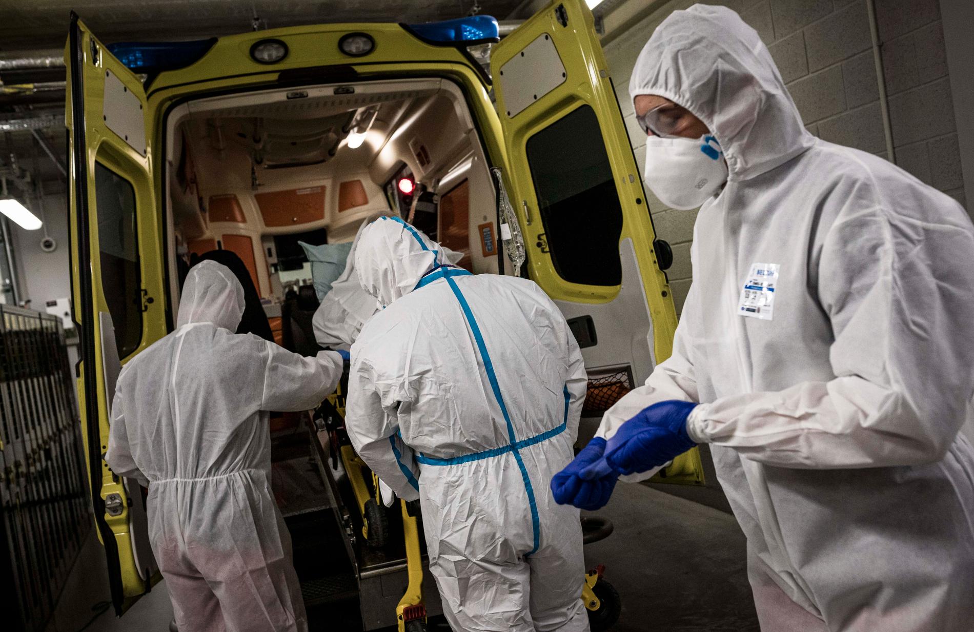 Sjukvårdspersonal i Liége förbereder för att ta ut en smittad patient ur en ambulans.