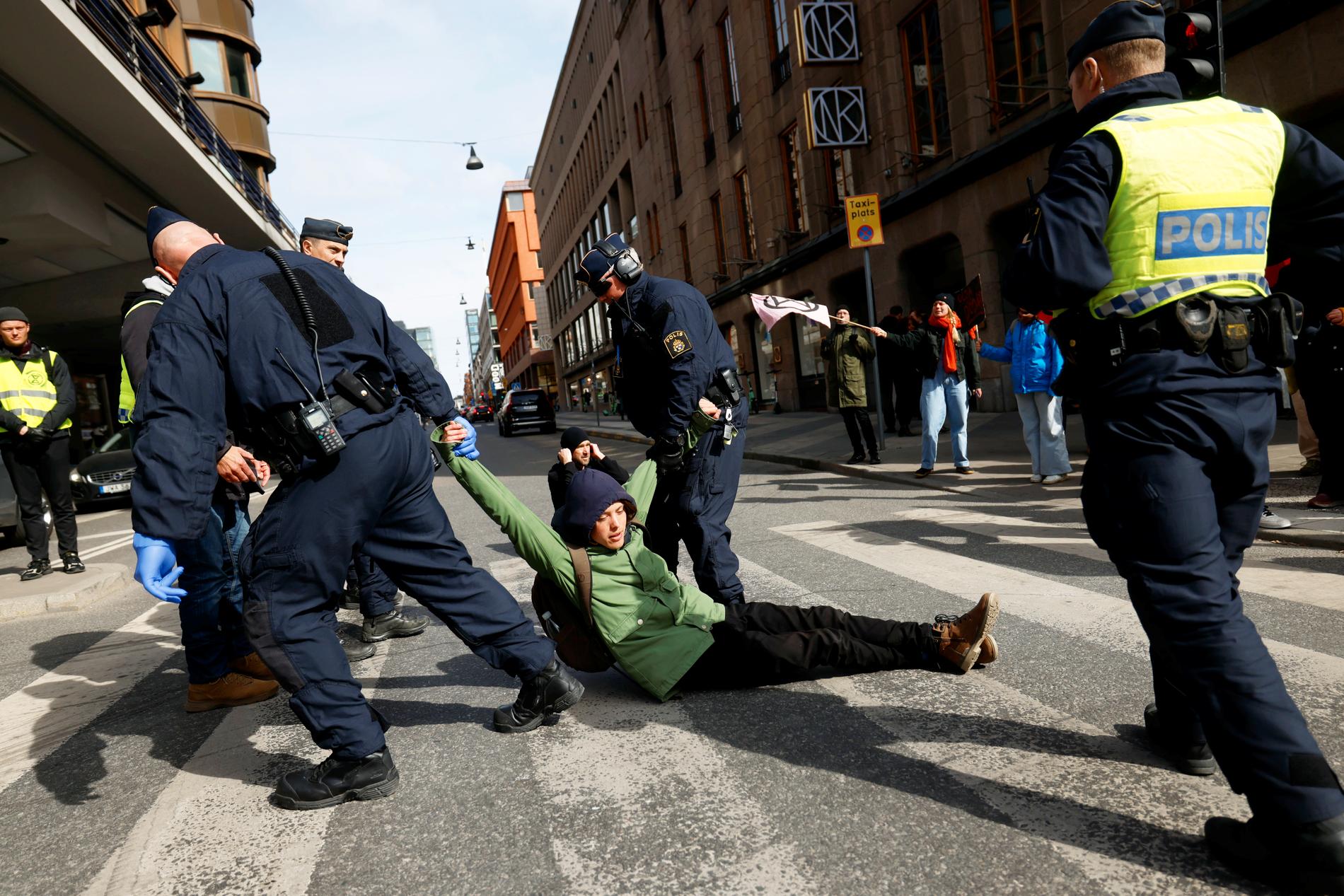 En klimataktivist släpas bort från Hamngatan i Stockholm.