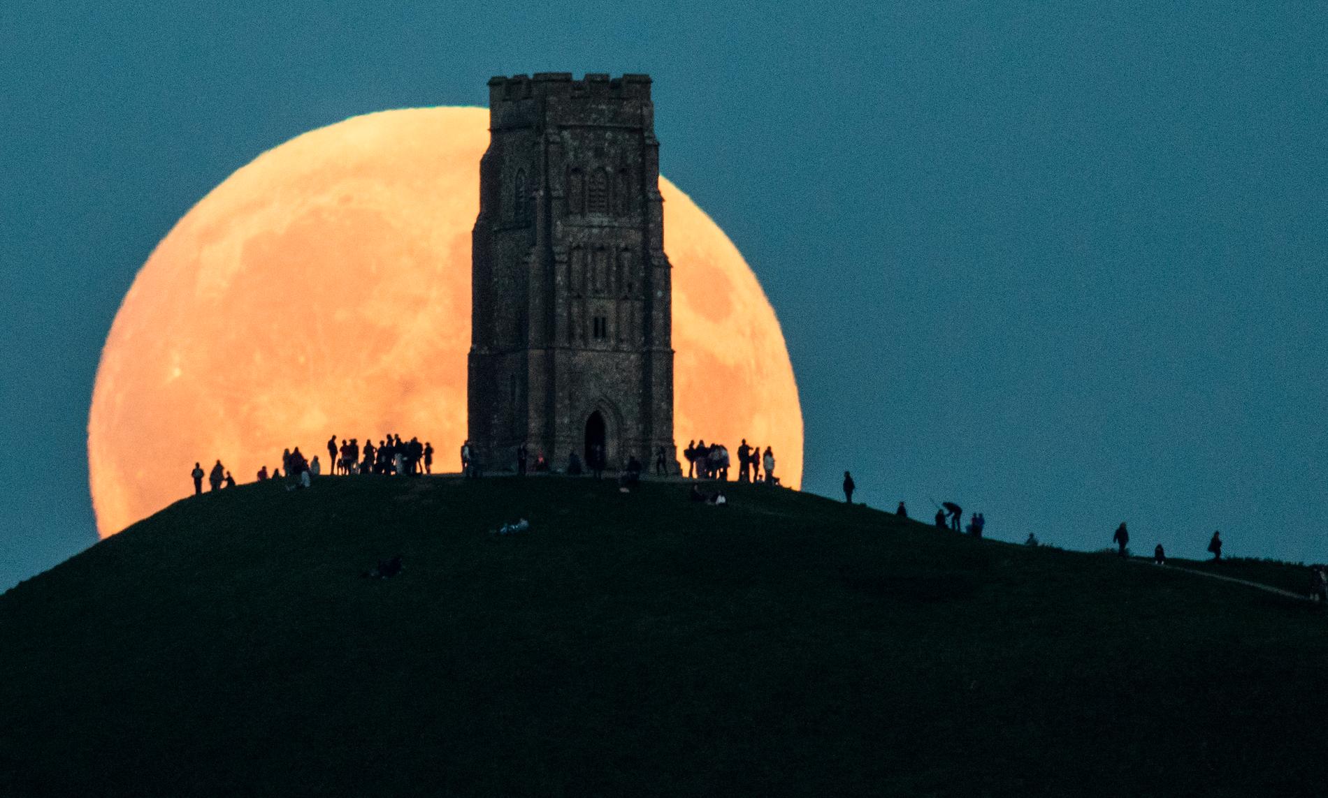 Supermånen syns bakom Glastonbury Tor, England.